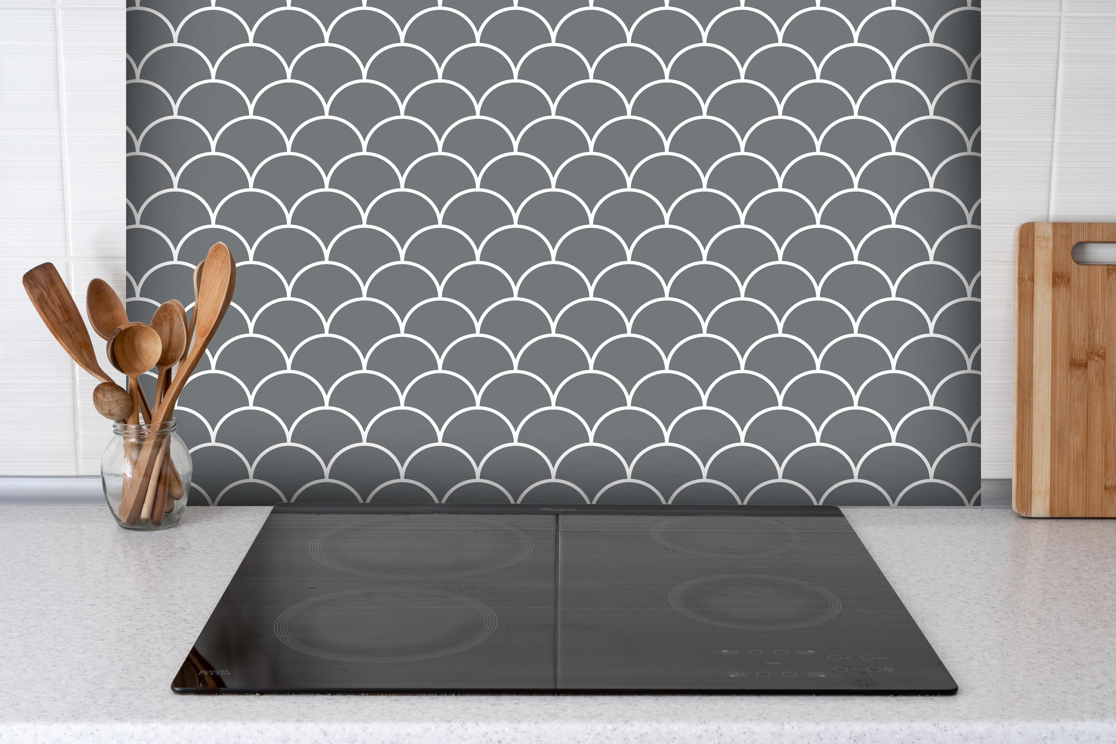 Spritzschutz - Simmetria Imperiale Piombo hinter einem Cerankochfeld zwischen Holz-Kochutensilien