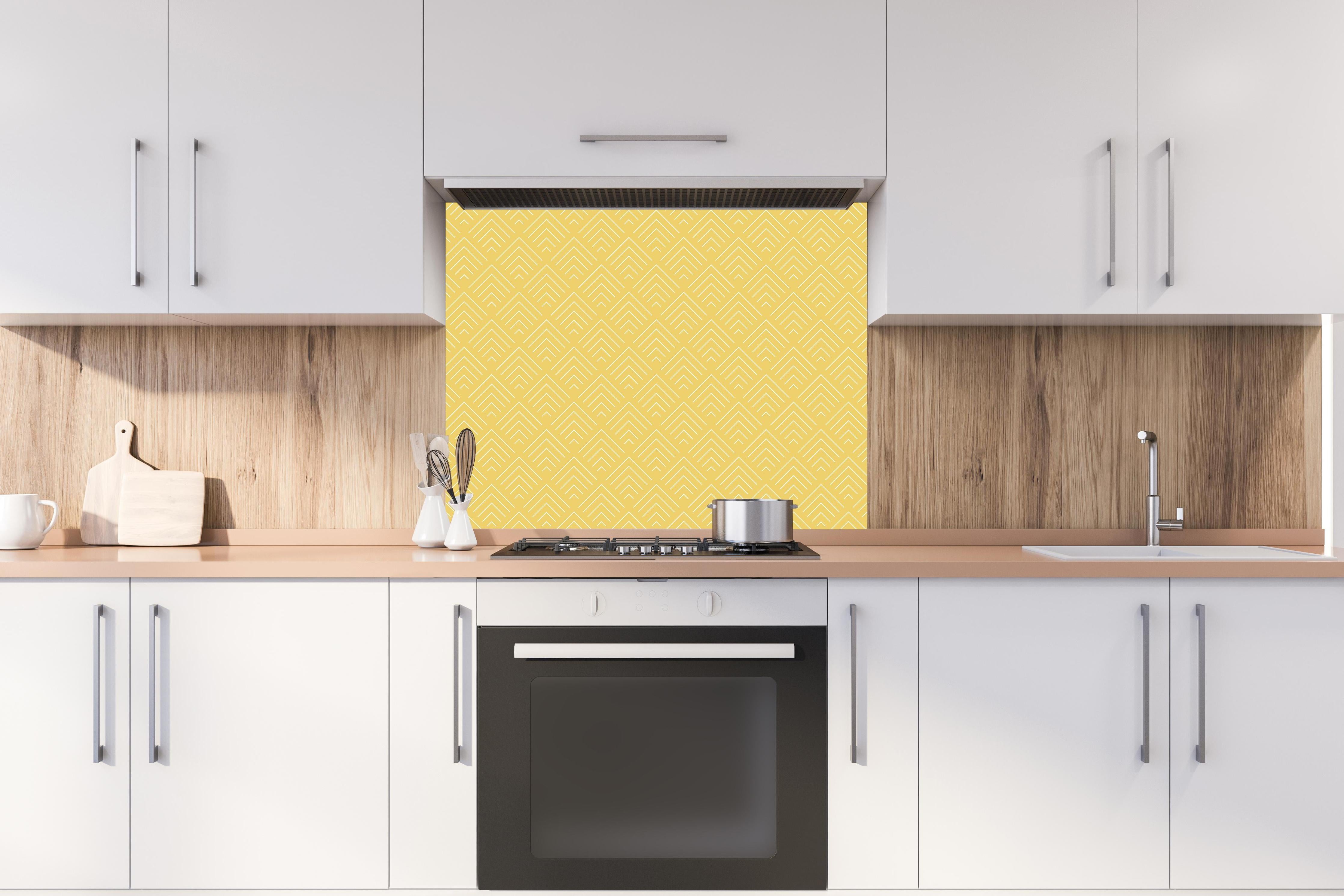 Spritzschutz - Simmetria Incanto Oro hinter einem Cerankochfeld zwischen Holz-Kochutensilien