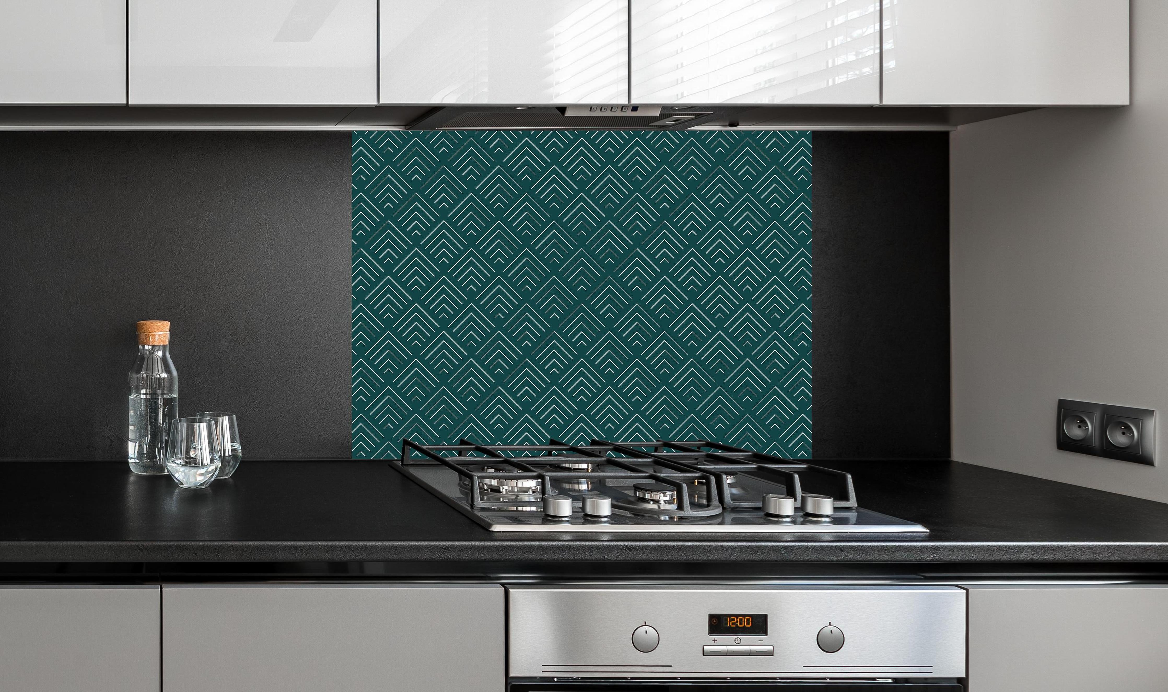 Spritzschutz - Simmetria Incanto Verde petrolio hinter einem Cerankochfeld zwischen Holz-Kochutensilien