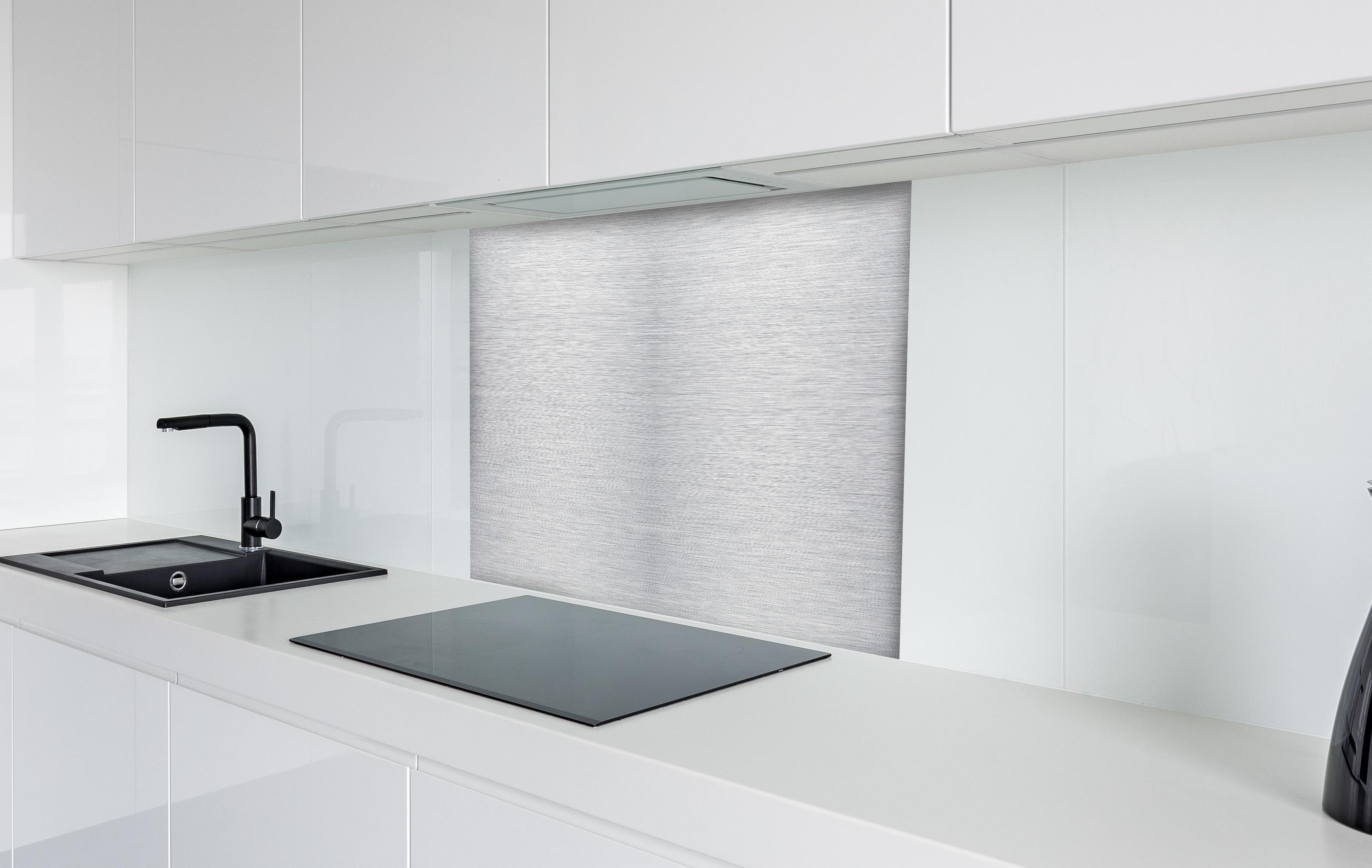 Spritzschutz - Skip hinter einem Cerankochfeld zwischen Holz-Kochutensilien