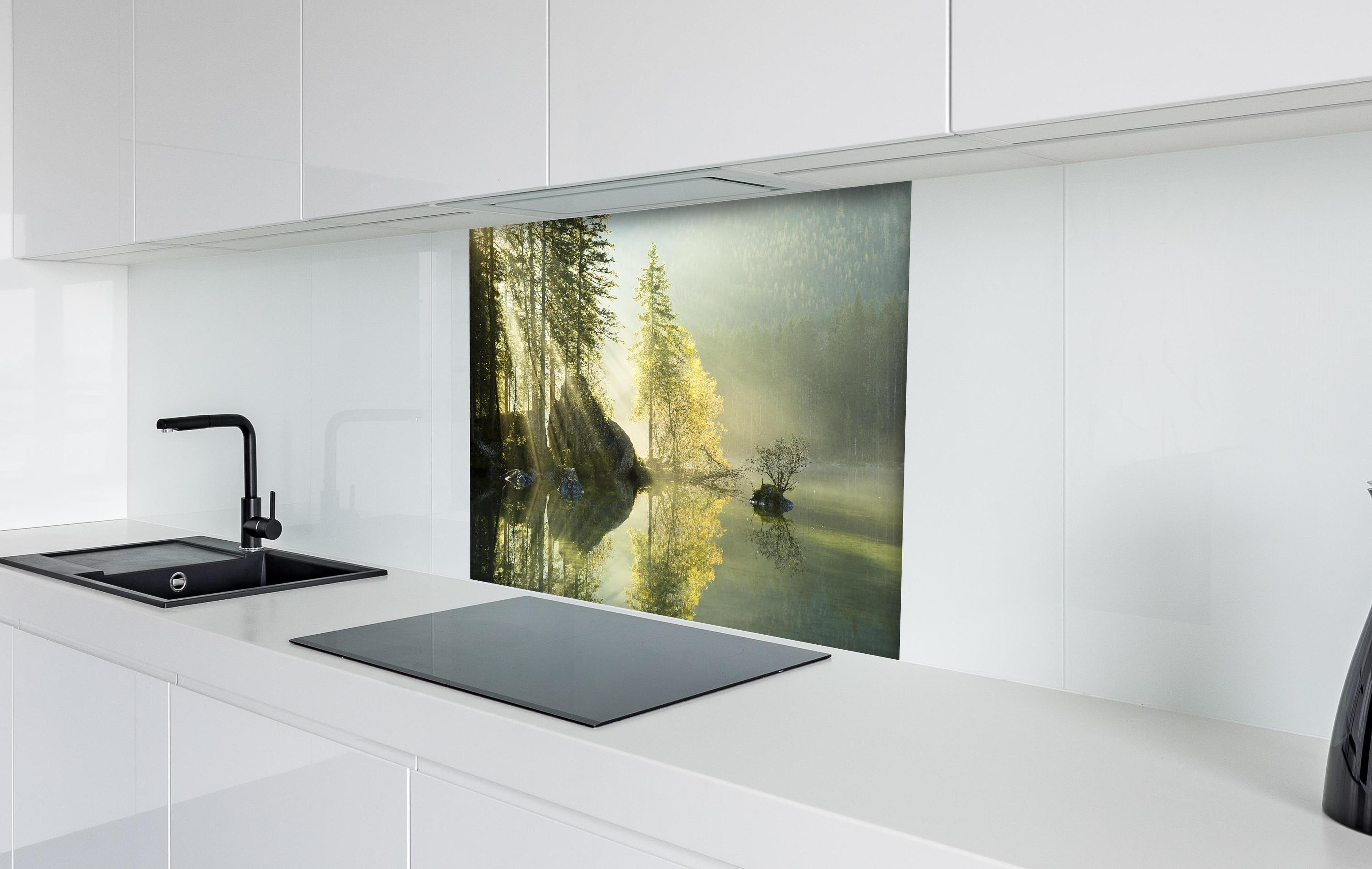 Spritzschutz - Sonnenstrahlen im See hinter einem Cerankochfeld zwischen Holz-Kochutensilien