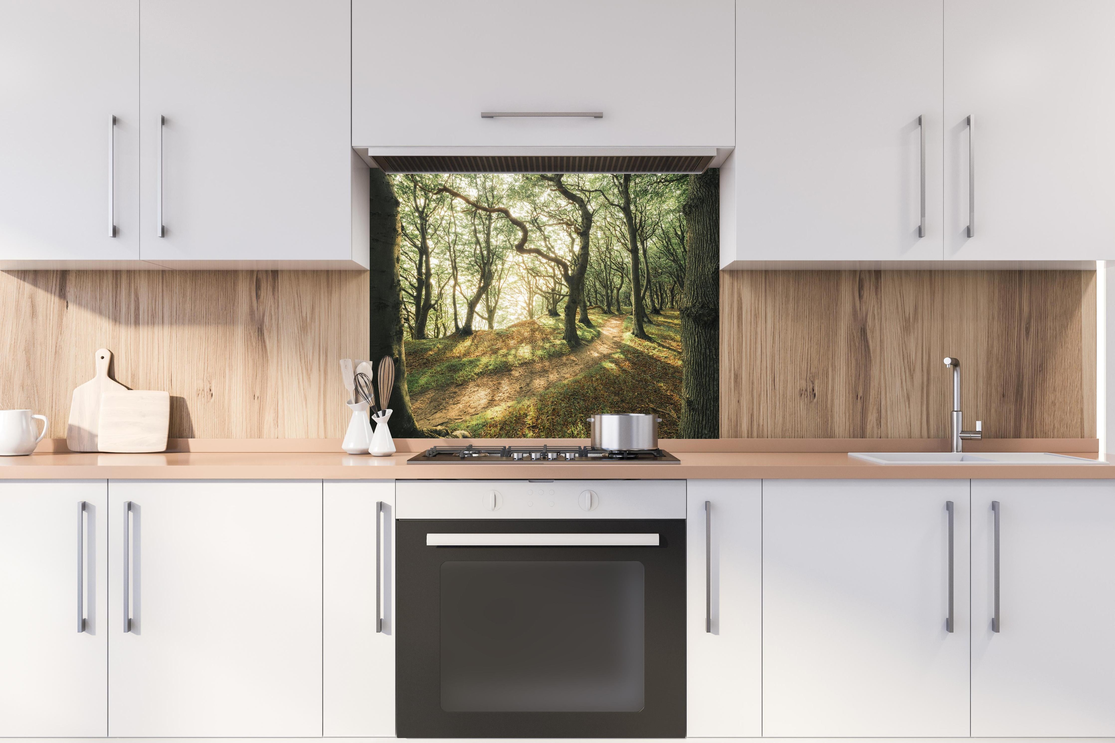 Spritzschutz - Sonnenstrahlen im Waldweg hinter einem Cerankochfeld zwischen Holz-Kochutensilien