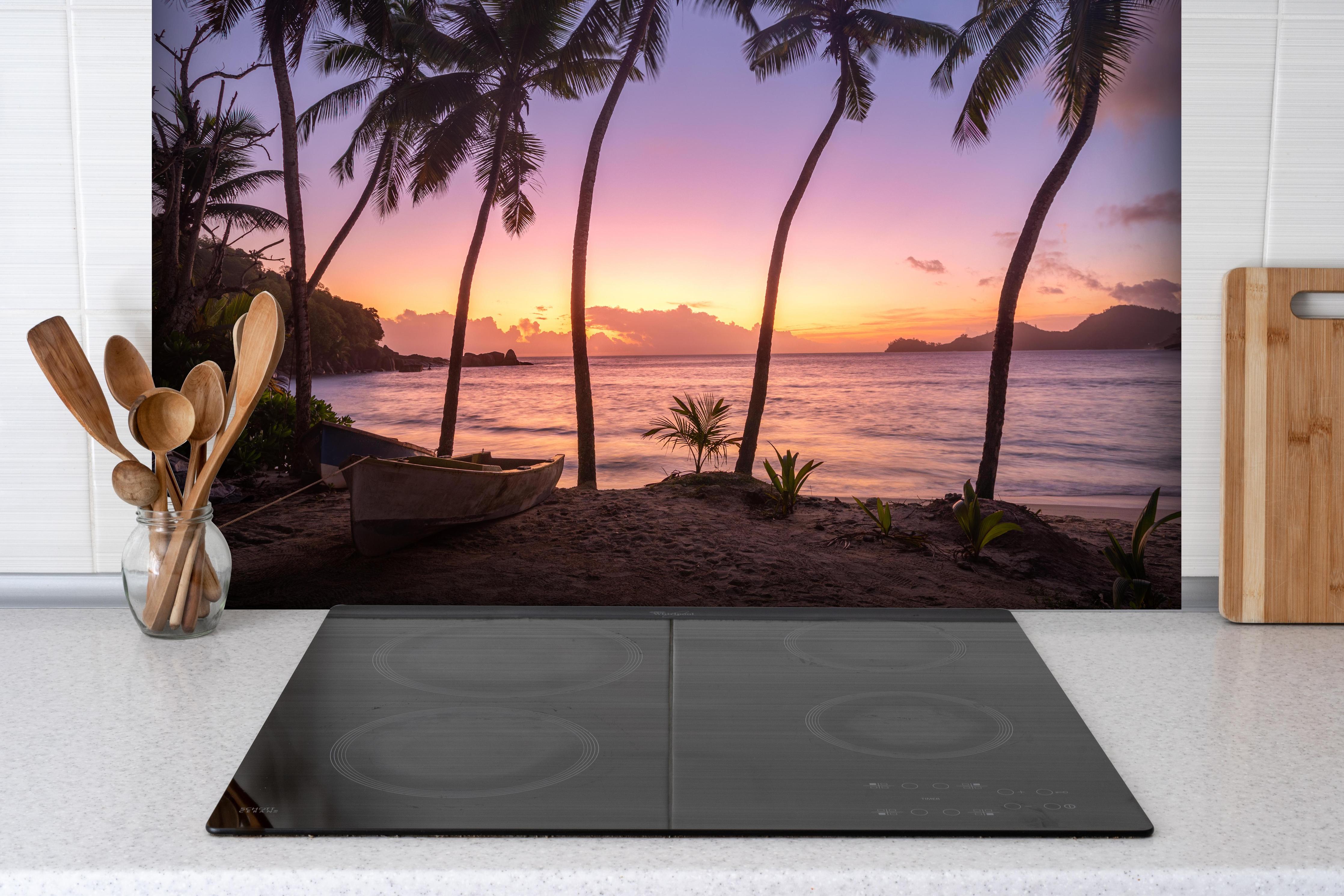 Spritzschutz - Sonnenuntergang am Strand Anse Takamaka hinter einem Cerankochfeld zwischen Holz-Kochutensilien