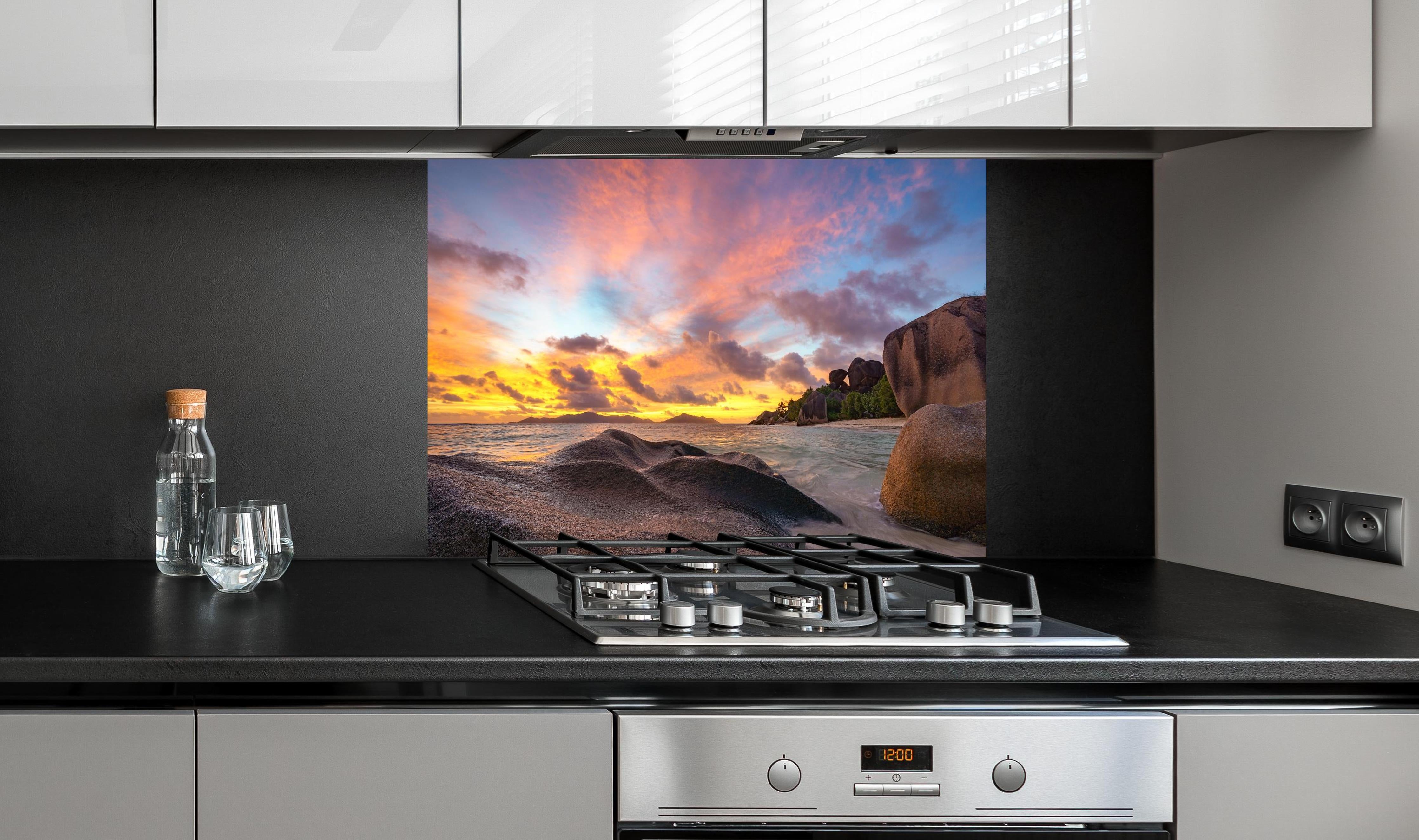 Spritzschutz - Sonnenuntergang am tropischen Strand hinter einem Cerankochfeld zwischen Holz-Kochutensilien