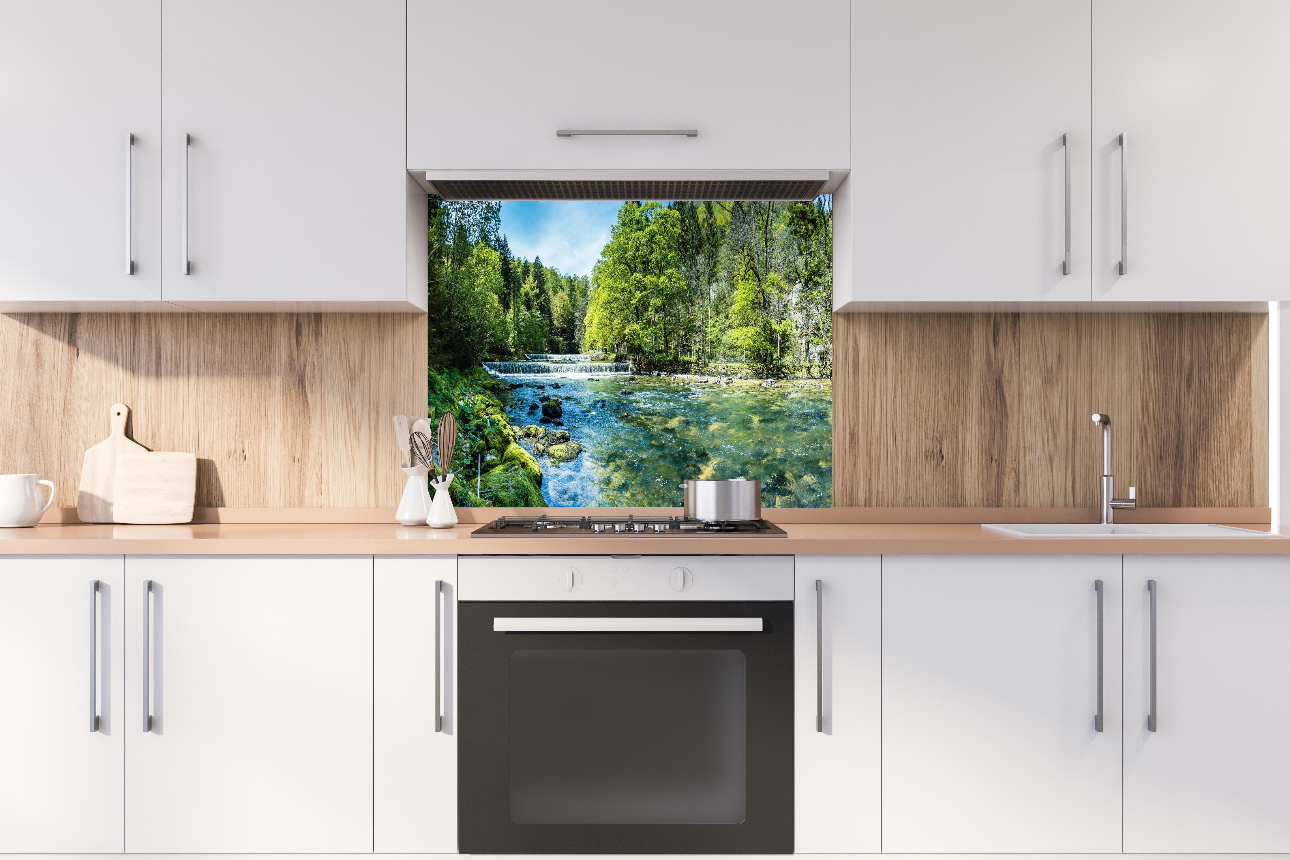 Spritzschutz - Sonnige Flusslandschaft in der Schweiz hinter einem Cerankochfeld zwischen Holz-Kochutensilien