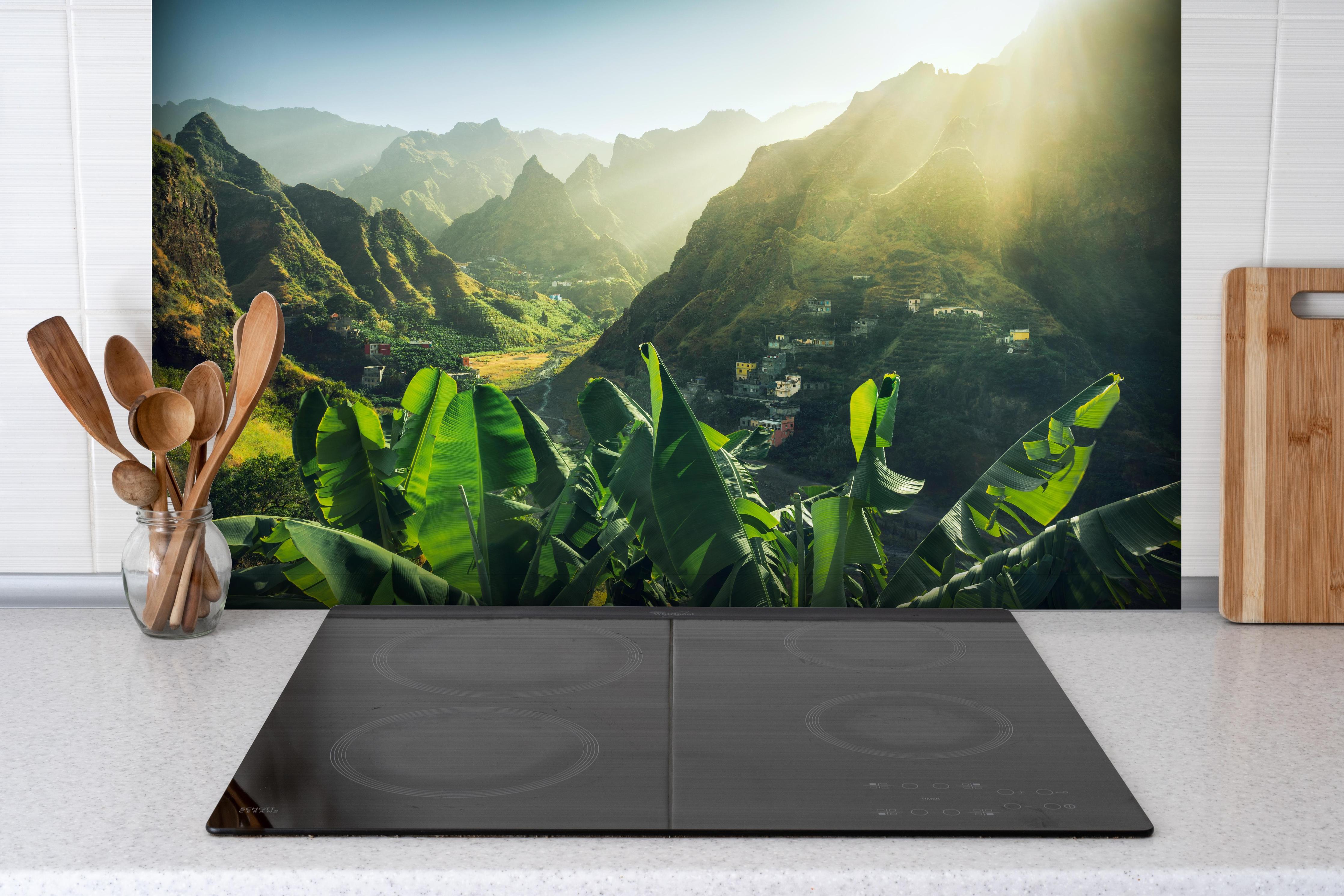 Spritzschutz - Sonniger Blick auf Kap Verde-Tal hinter einem Cerankochfeld zwischen Holz-Kochutensilien