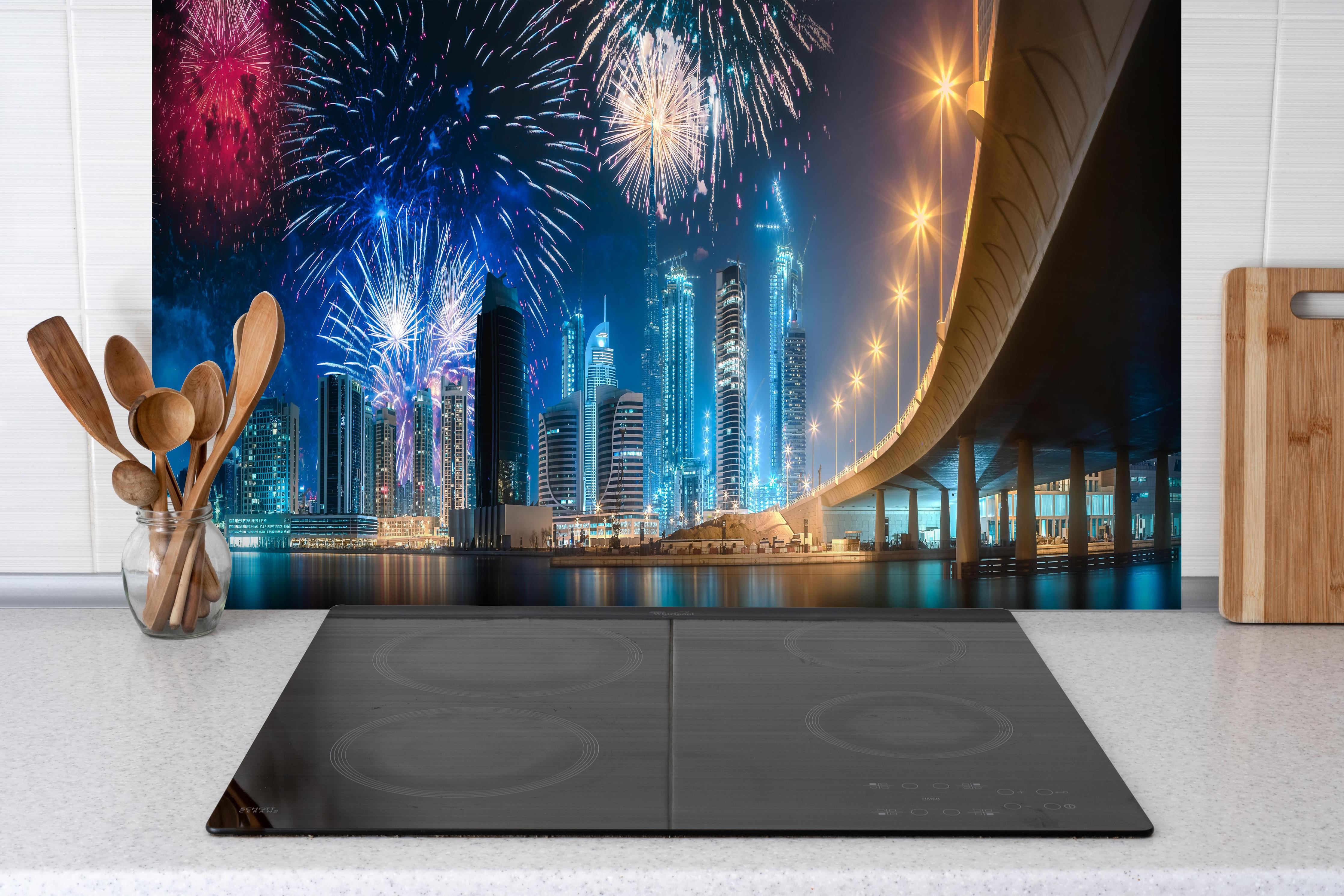 Spritzschutz - Spektakuläres Feuerwerk Dubai Business Bay hinter einem Cerankochfeld zwischen Holz-Kochutensilien