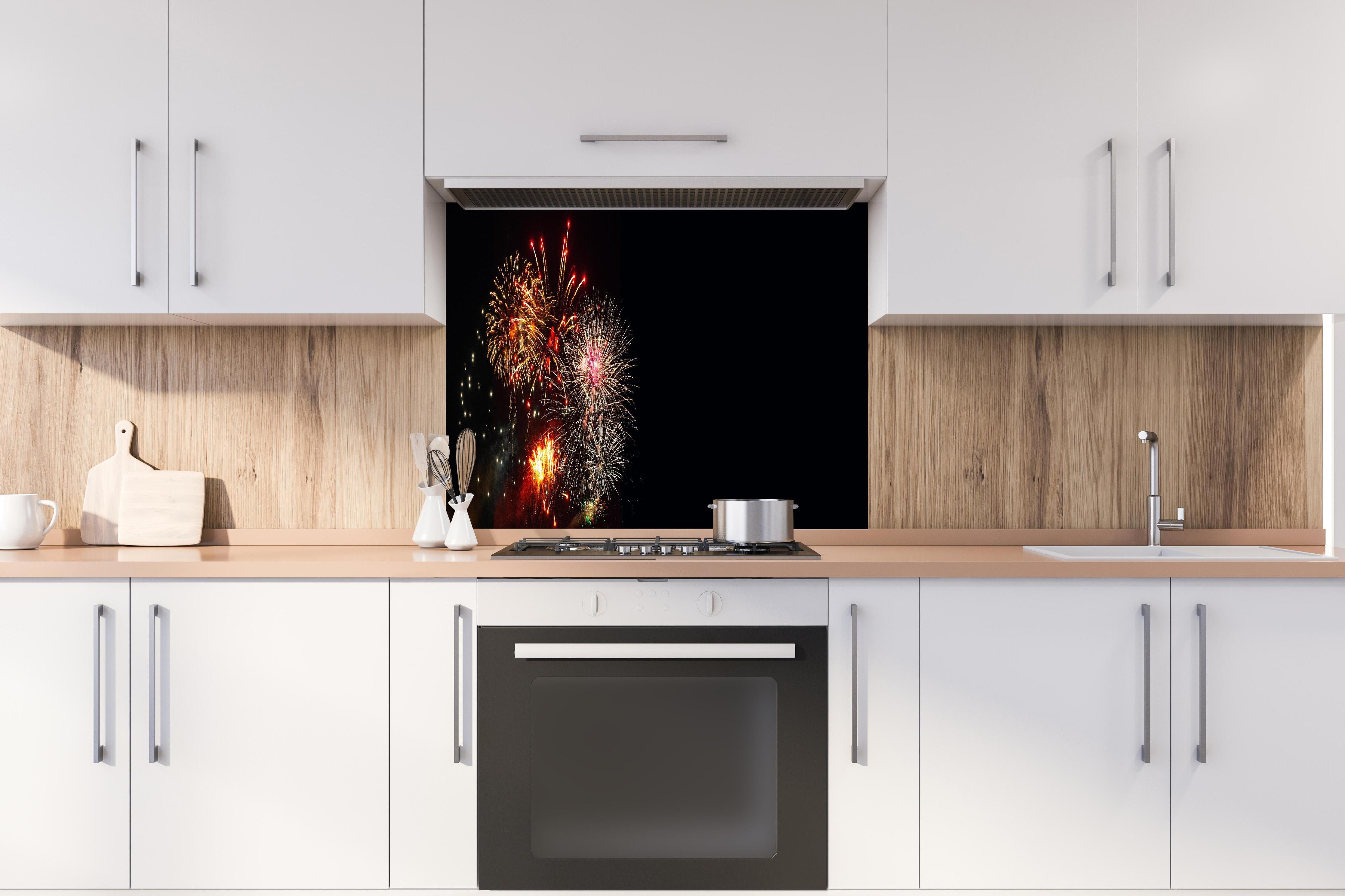 Spritzschutz - Spektakuläres Neujahrsfeuerwerk in Nacht hinter einem Cerankochfeld zwischen Holz-Kochutensilien