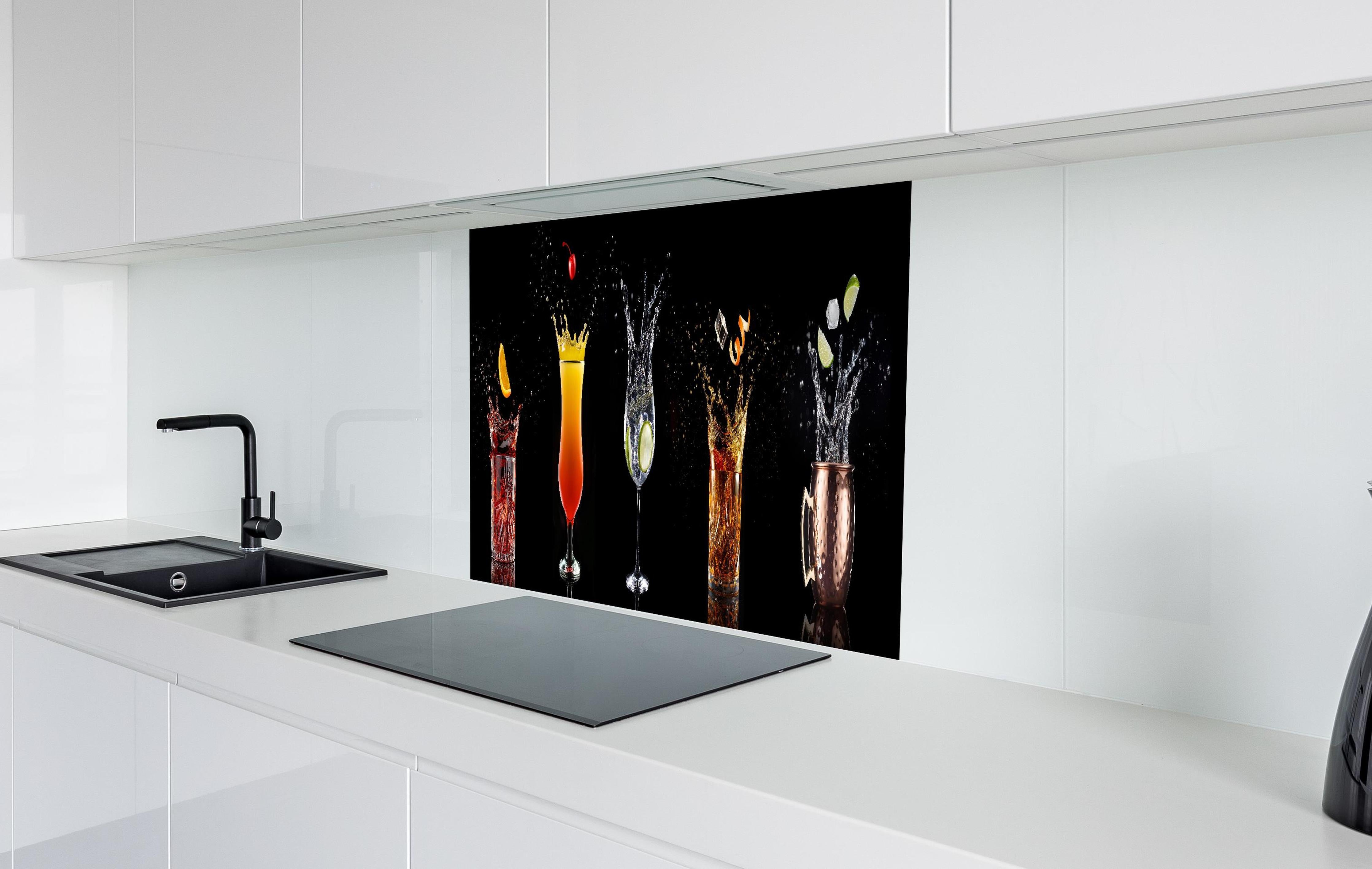 Spritzschutz - Splash-Effekt mit Cocktails auf Schwarz hinter einem Cerankochfeld zwischen Holz-Kochutensilien