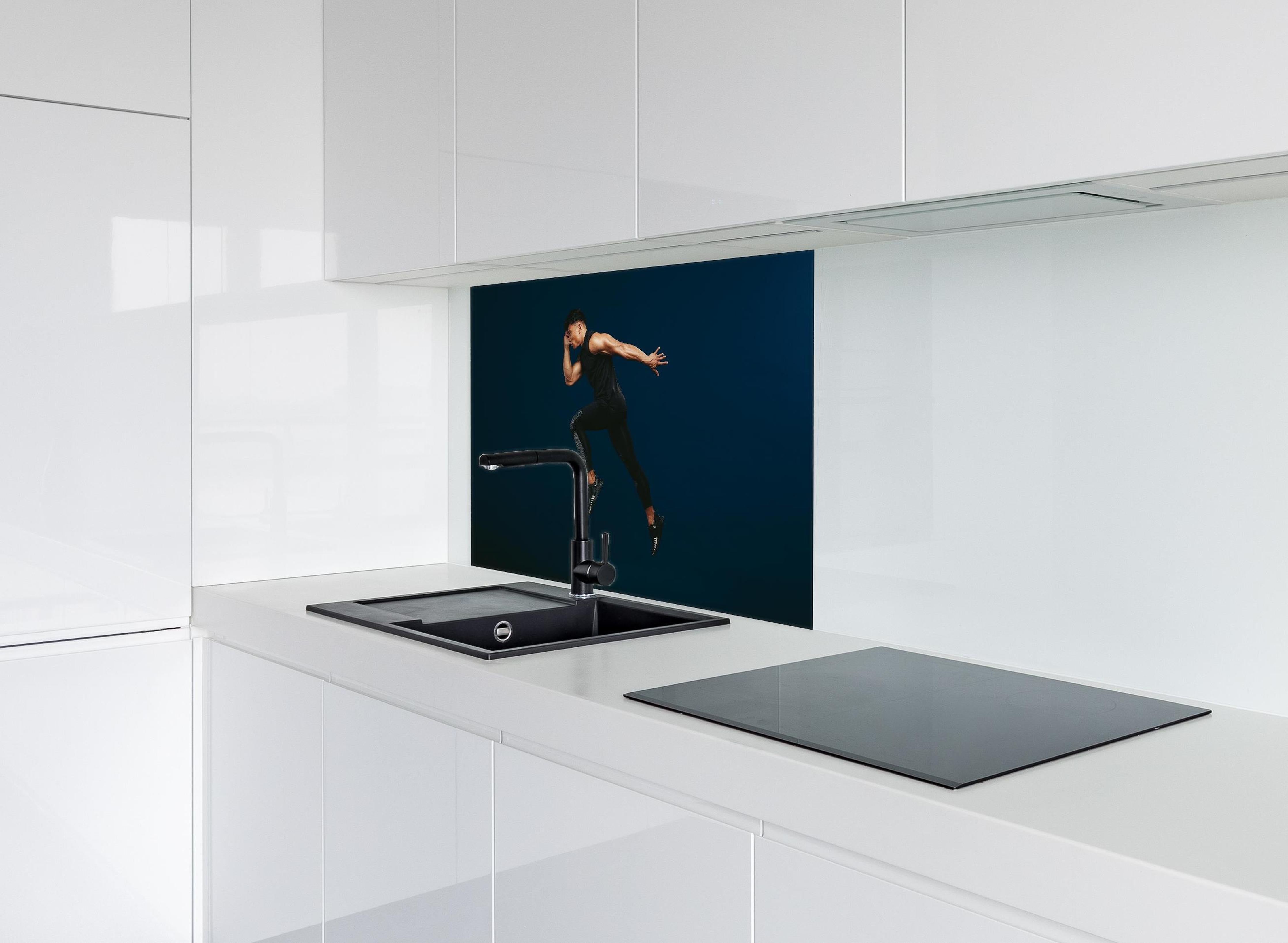 Spritzschutz - Sportler bei einem Sprung hinter einem Cerankochfeld zwischen Holz-Kochutensilien