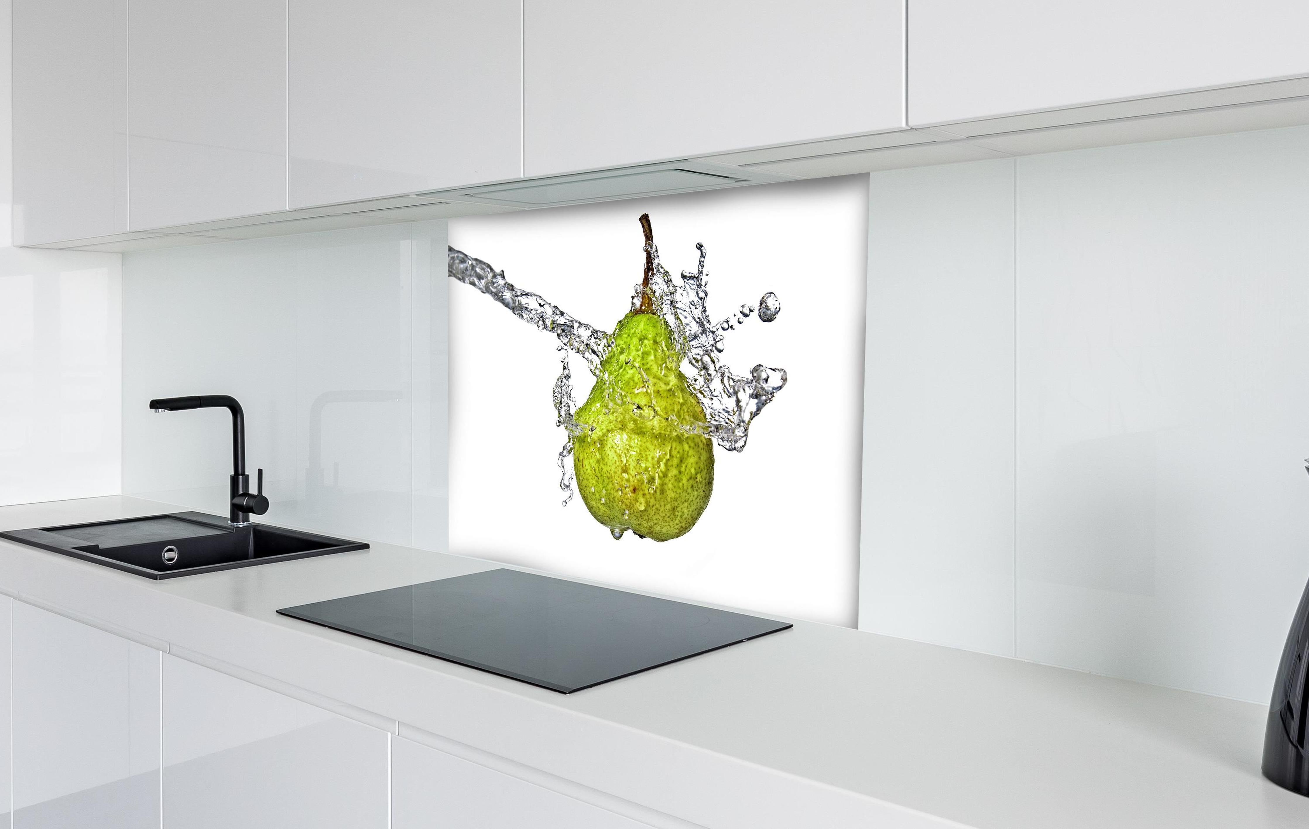 Spritzschutz - Spritzige Birne hinter einem Cerankochfeld zwischen Holz-Kochutensilien