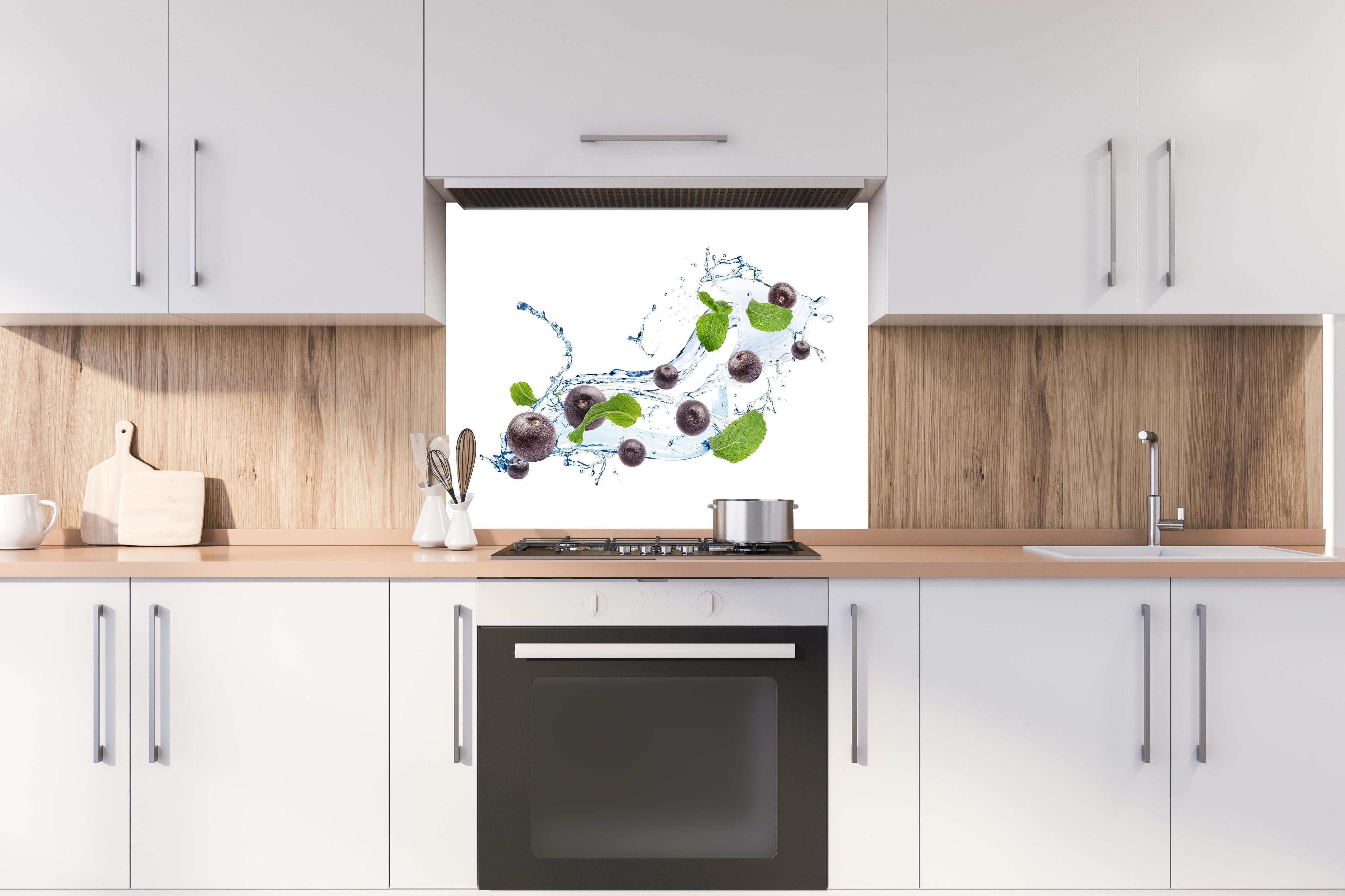 Spritzschutz - Spritzige Blaubeeren hinter einem Cerankochfeld zwischen Holz-Kochutensilien