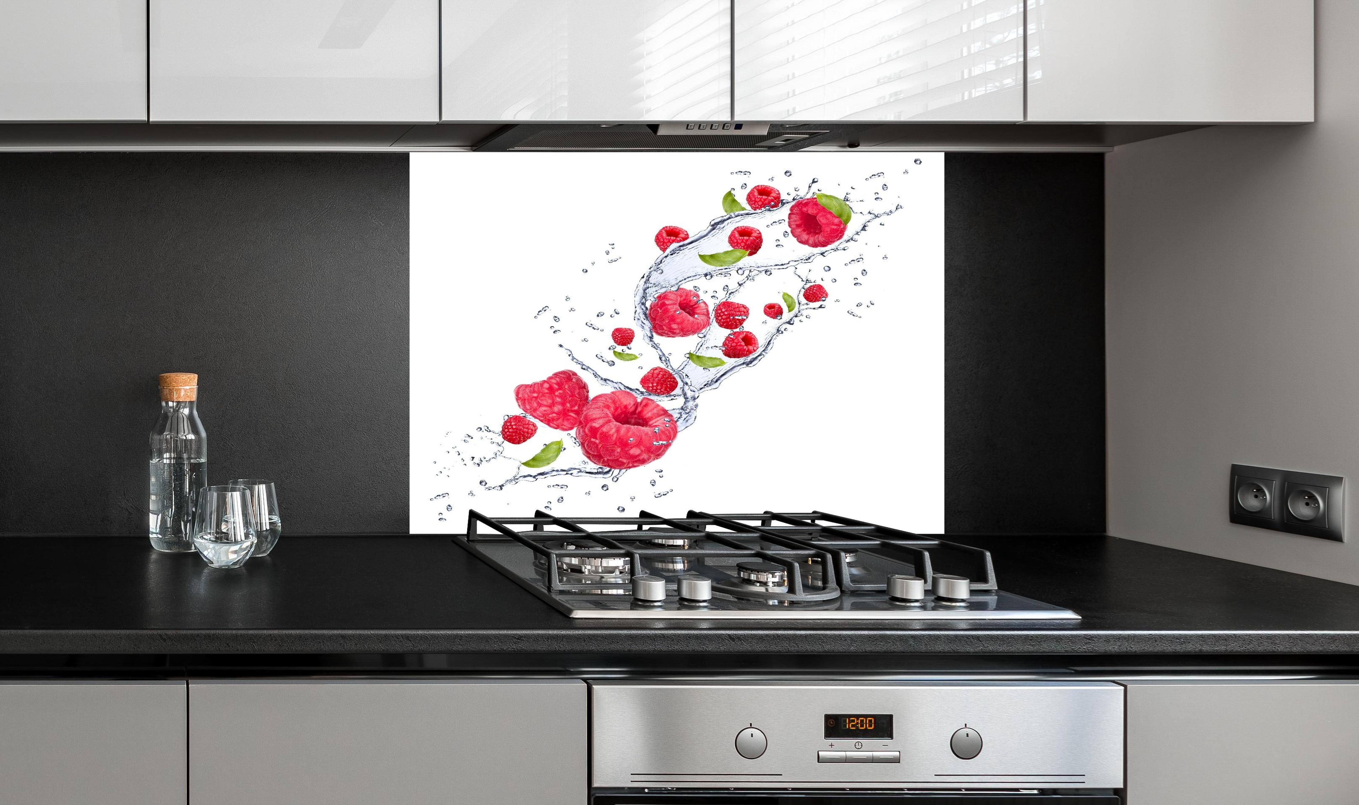 Spritzschutz - Spritzige Erdbeeren hinter einem Cerankochfeld zwischen Holz-Kochutensilien