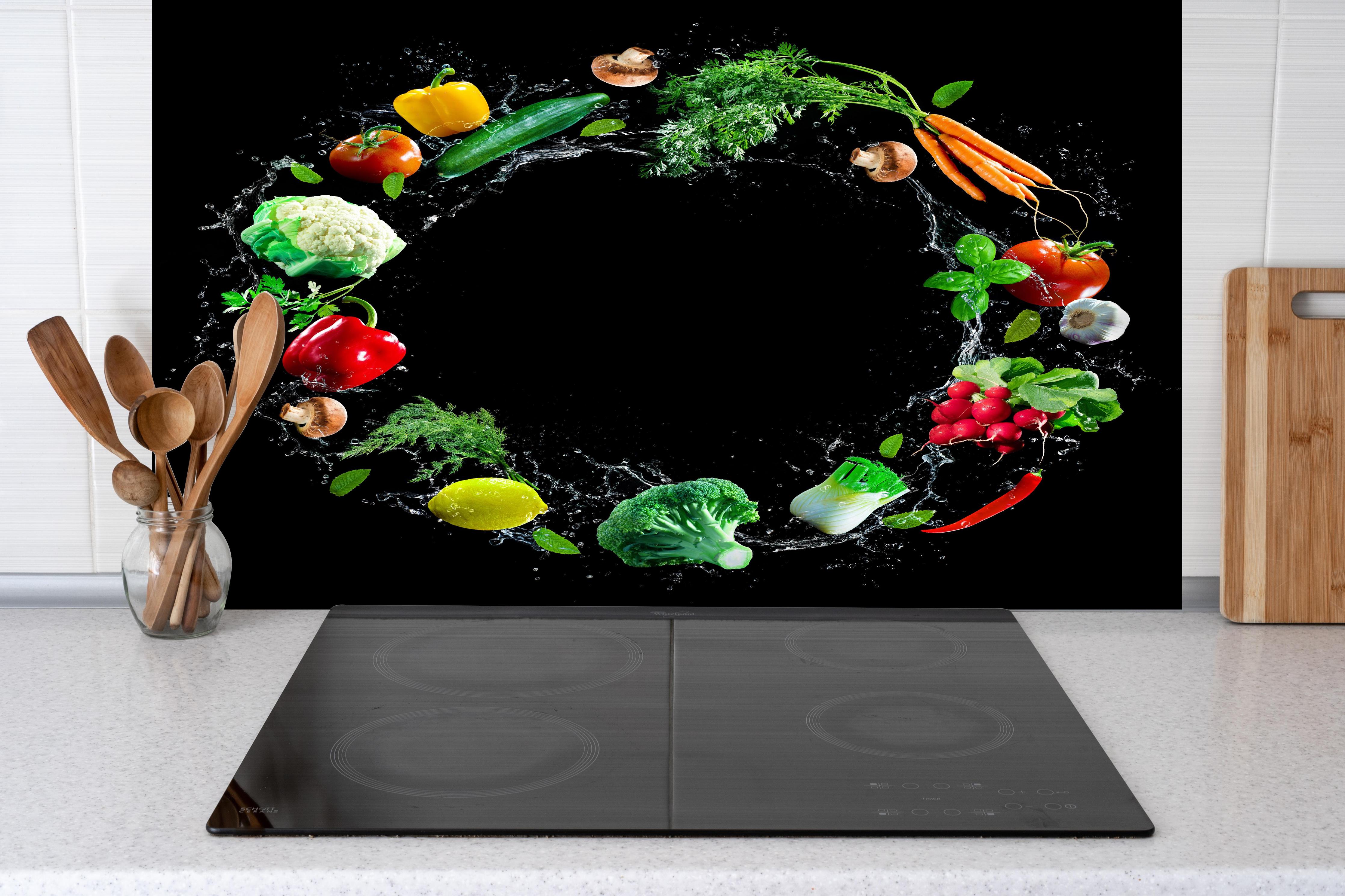 Spritzschutz - Spritzige Gemüsesorten hinter einem Cerankochfeld zwischen Holz-Kochutensilien