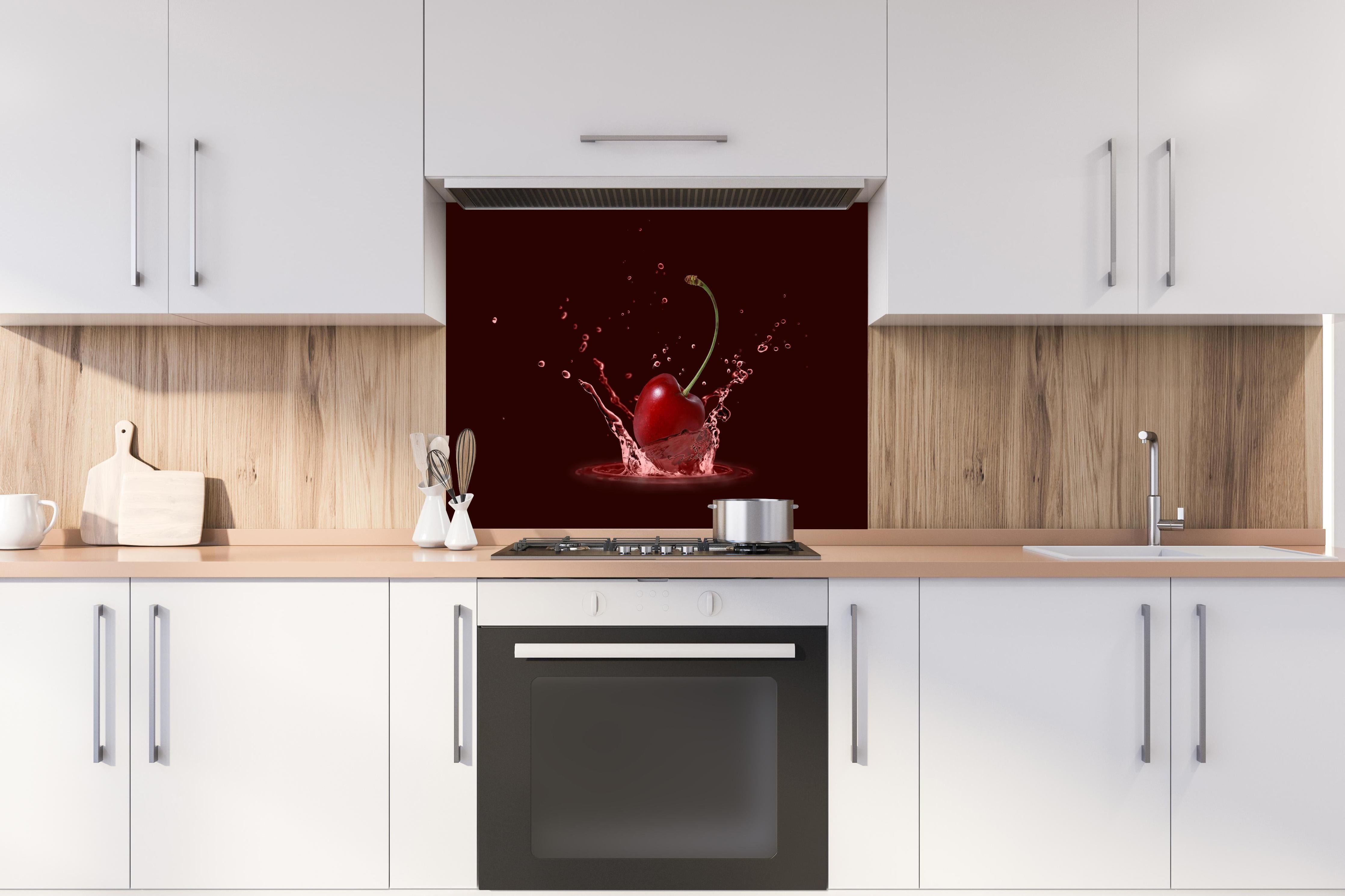 Spritzschutz - Spritzige Kirsche hinter einem Cerankochfeld zwischen Holz-Kochutensilien