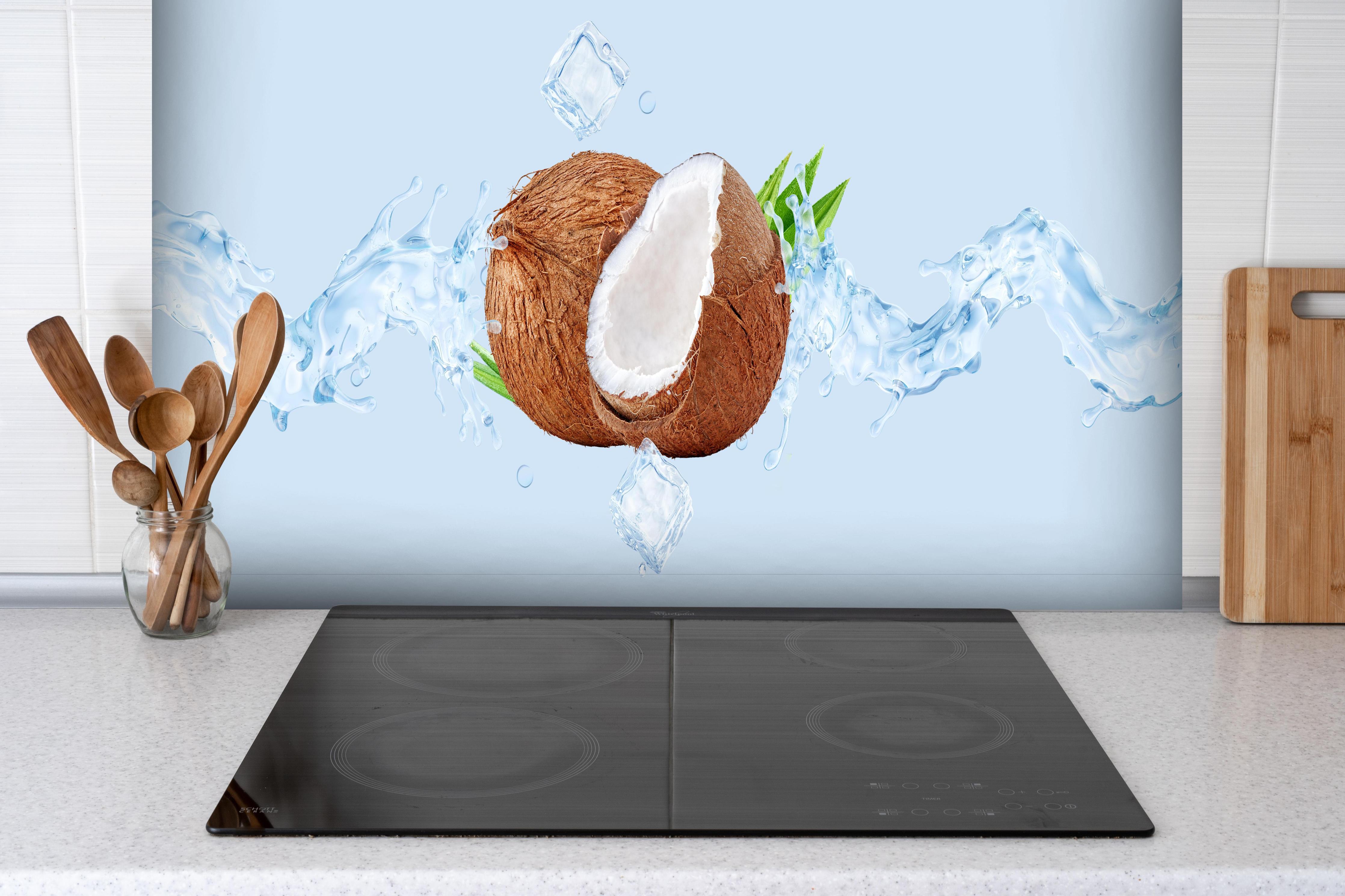 Spritzschutz - Spritzige Kokosnüsse hinter einem Cerankochfeld zwischen Holz-Kochutensilien