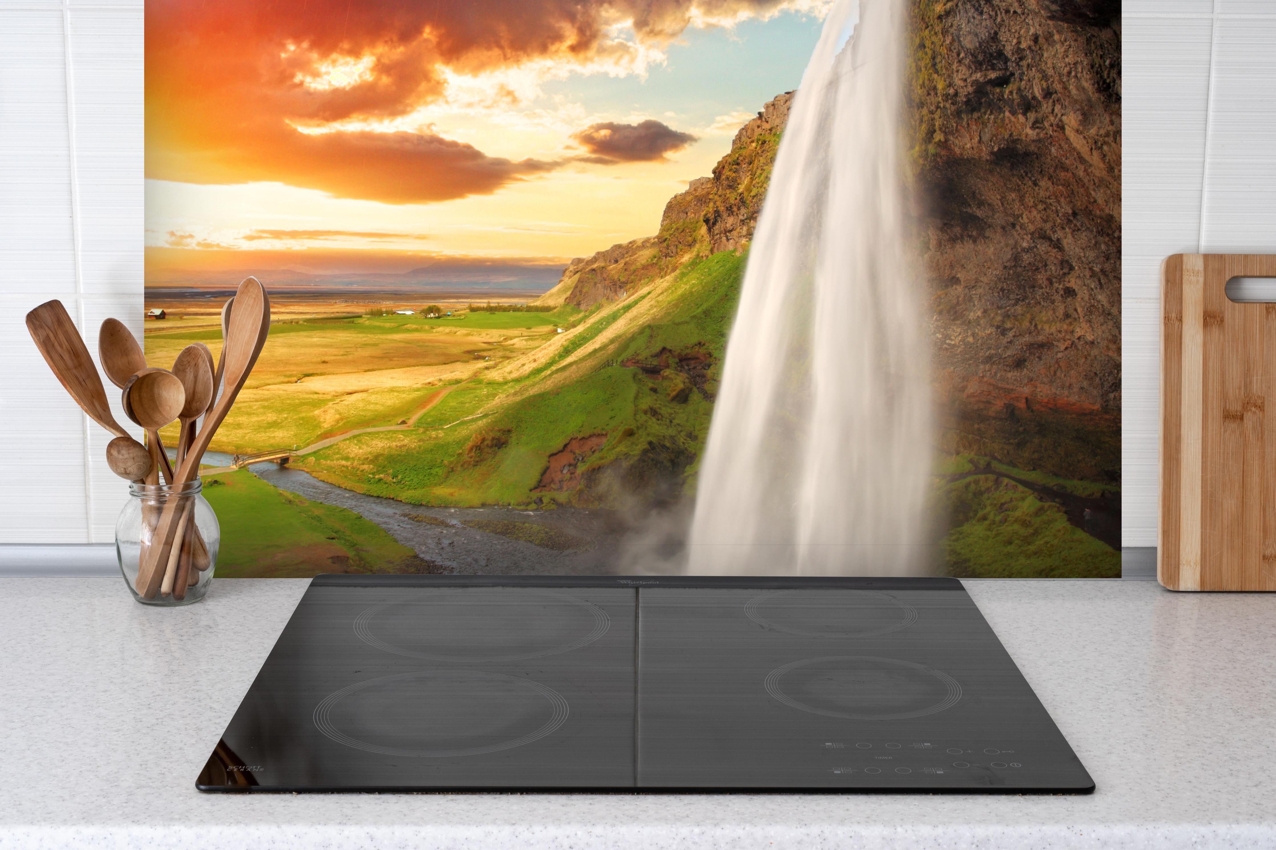 Spritzschutz - Seljalandsfoss Wasserfall bei Sonnenuntergang hinter einem Cerankochfeld zwischen Holz-Kochutensilien