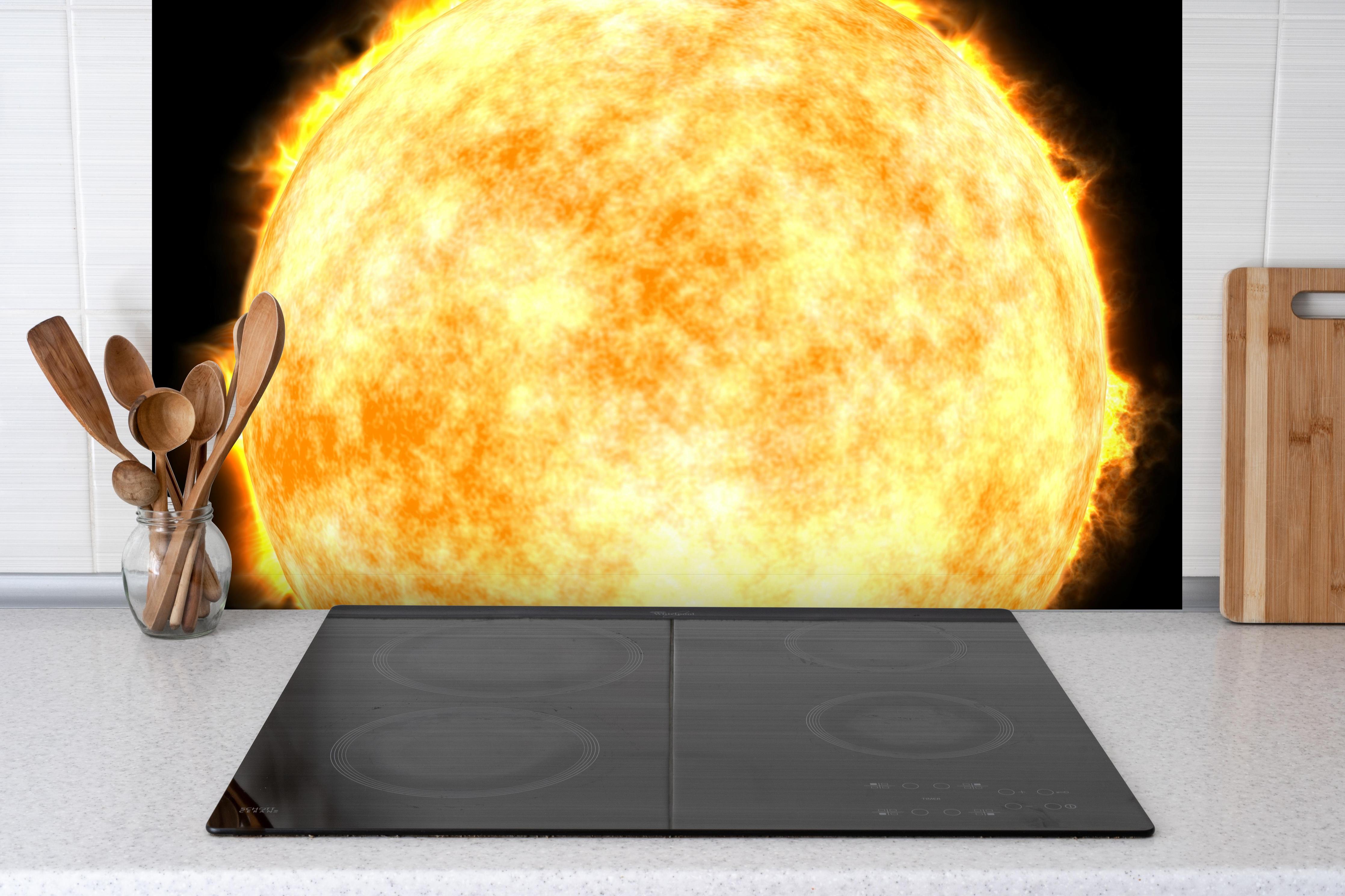 Spritzschutz - Sonne auf Schwarzem Hintergrund hinter einem Cerankochfeld zwischen Holz-Kochutensilien