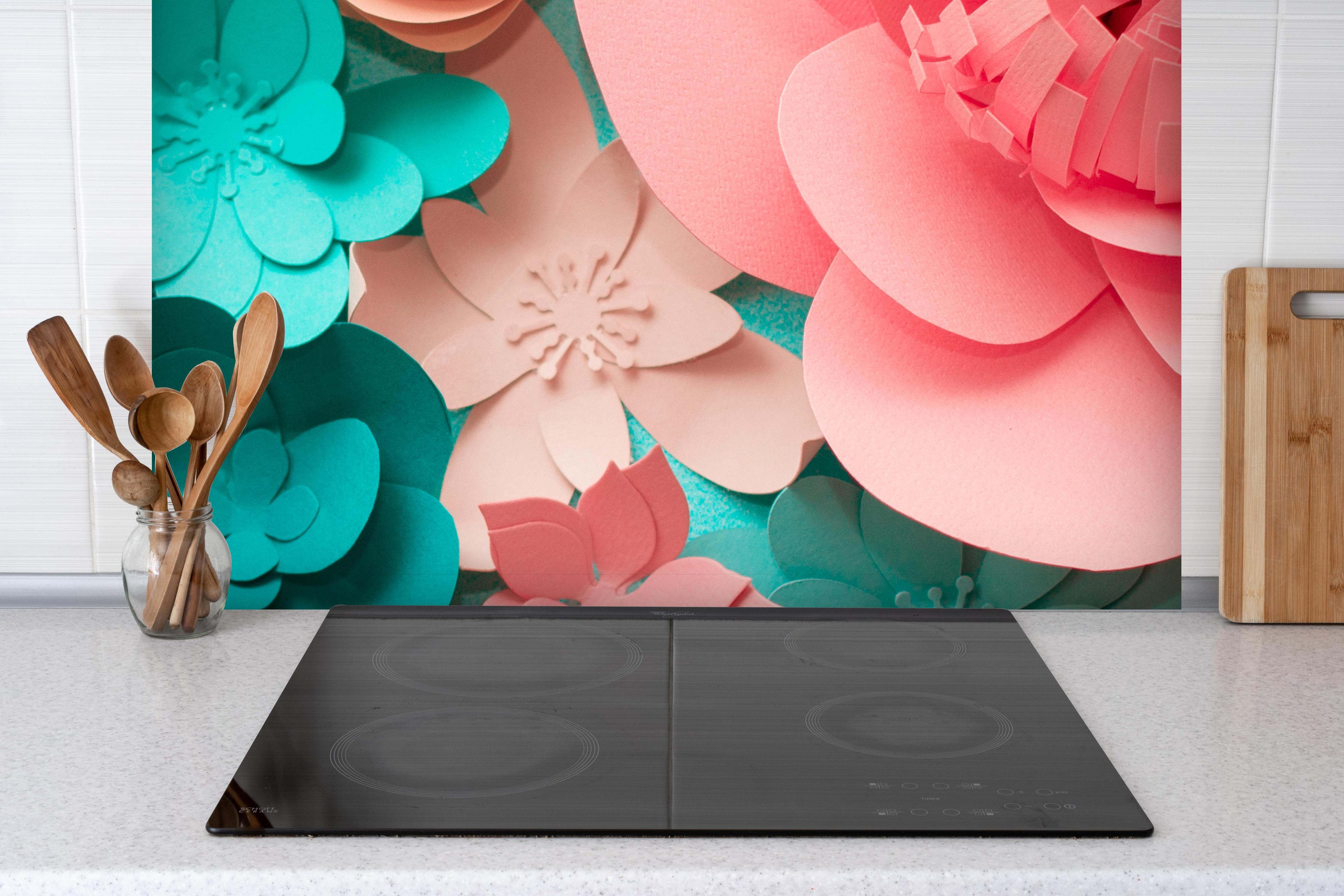 Spritzschutz - bunte Papier Blumen Komposition hinter einem Cerankochfeld zwischen Holz-Kochutensilien