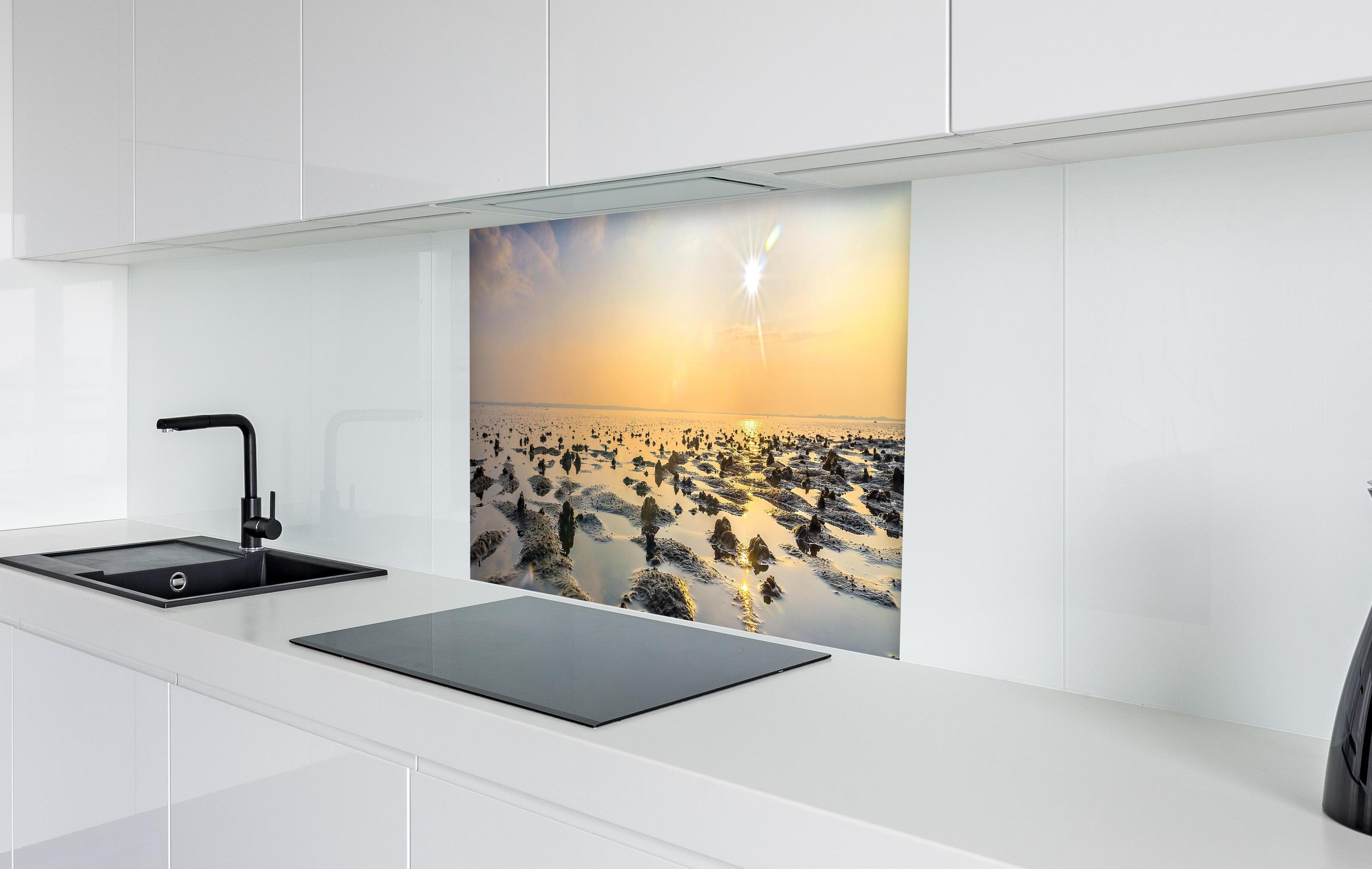Spritzschutz - endlose Küste der Nordsee in weißer Hochglanz-Küche hinter einem Cerankochfeld