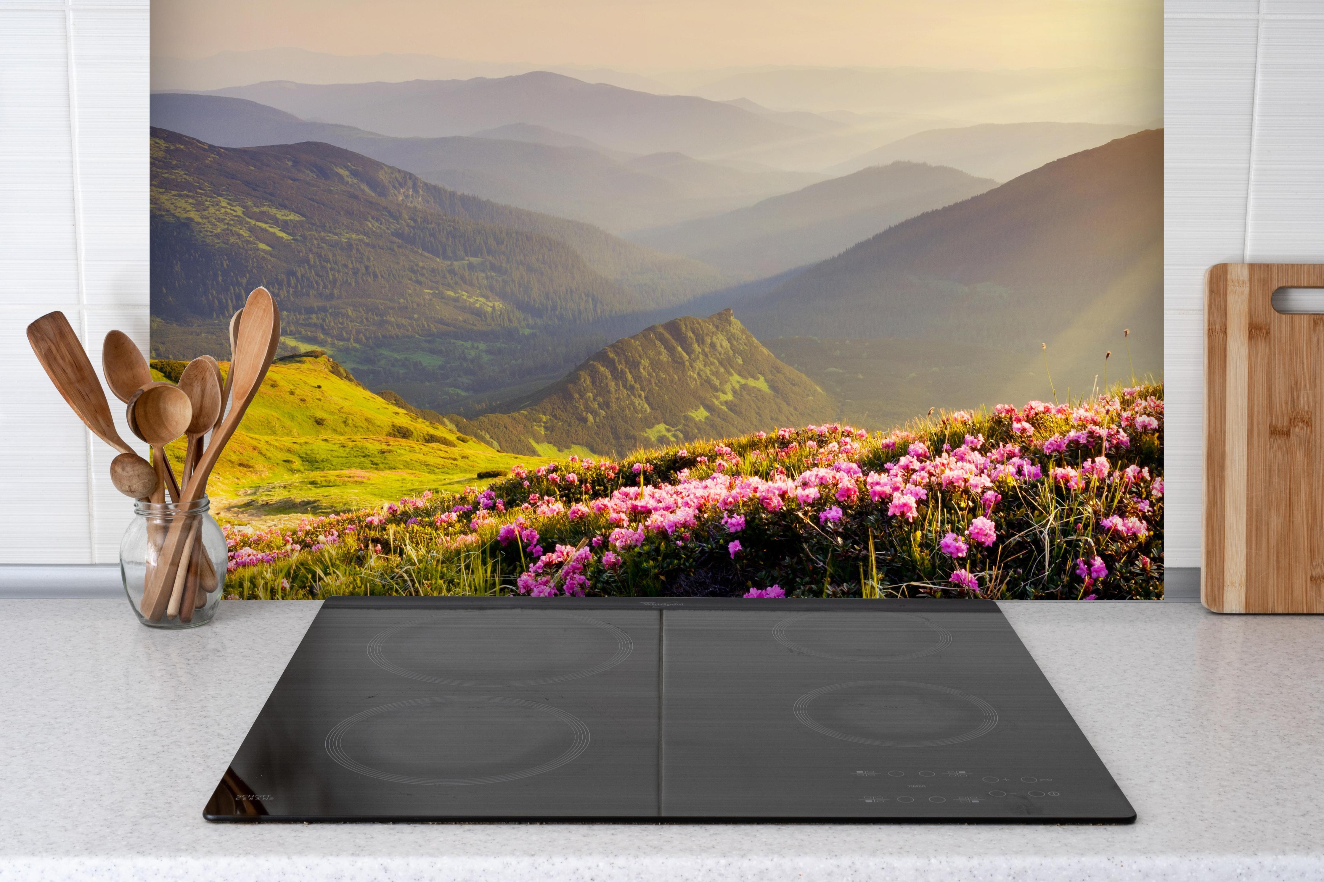 Spritzschutz - ruhige Berglandschaft in der Schweiz hinter einem Cerankochfeld zwischen Holz-Kochutensilien