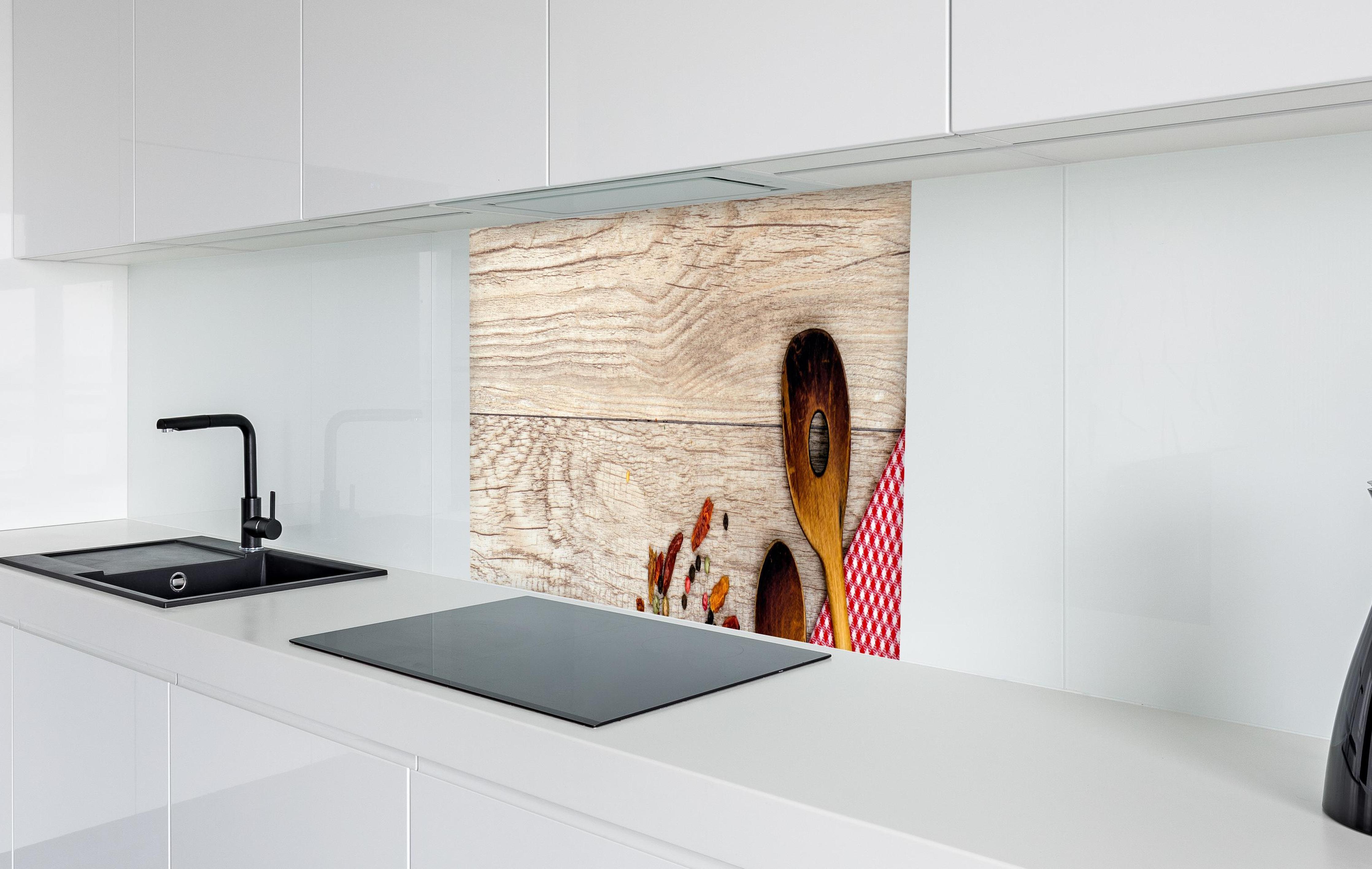 Spritzschutz - trockenes Gemüse durcheinander auf Holz in weißer Hochglanz-Küche hinter einem Cerankochfeld