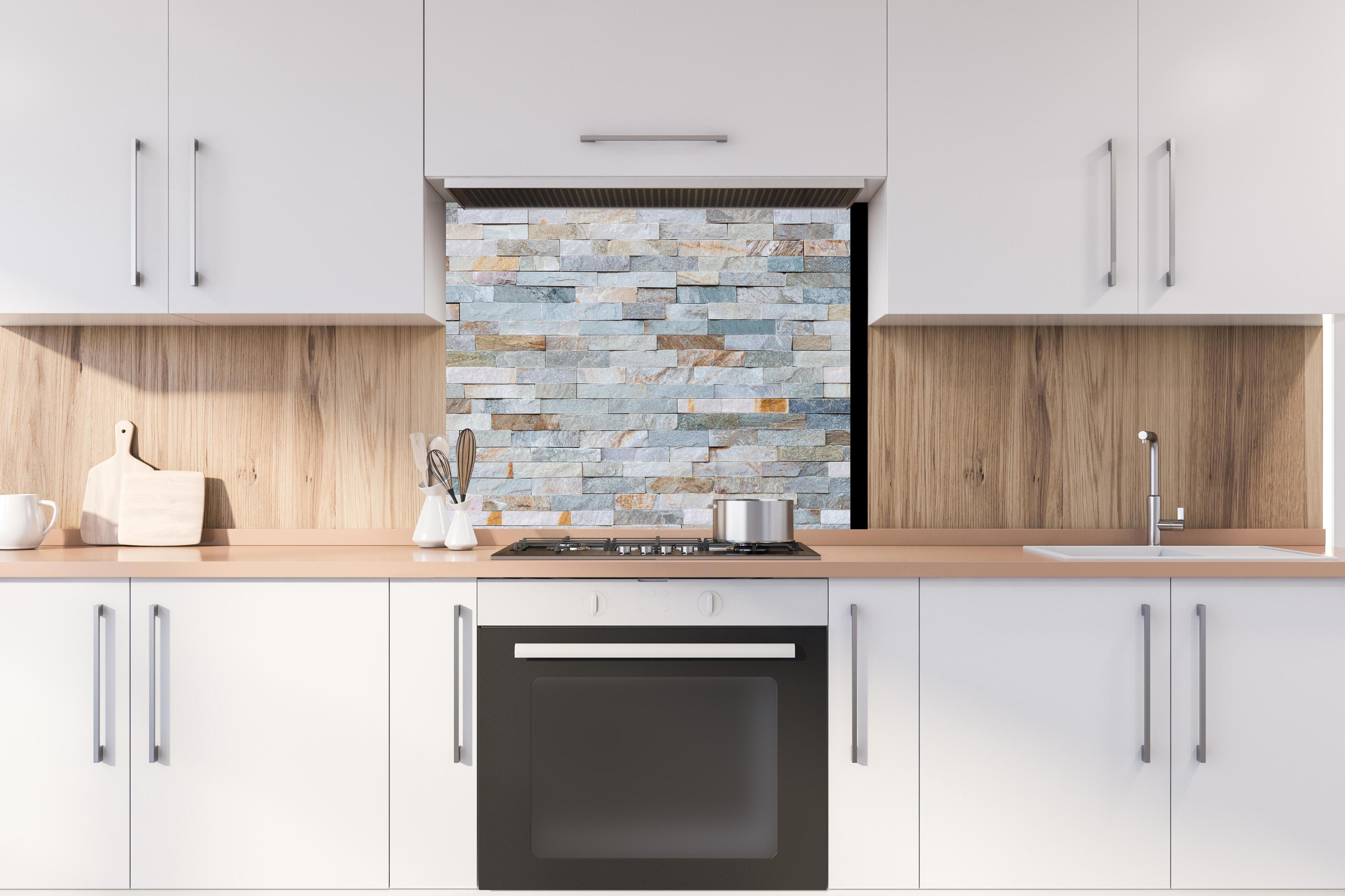 Spritzschutz - Abstrakte Steinwandmuster hinter stilvollem Gasherd unter Dunstabzugshaube