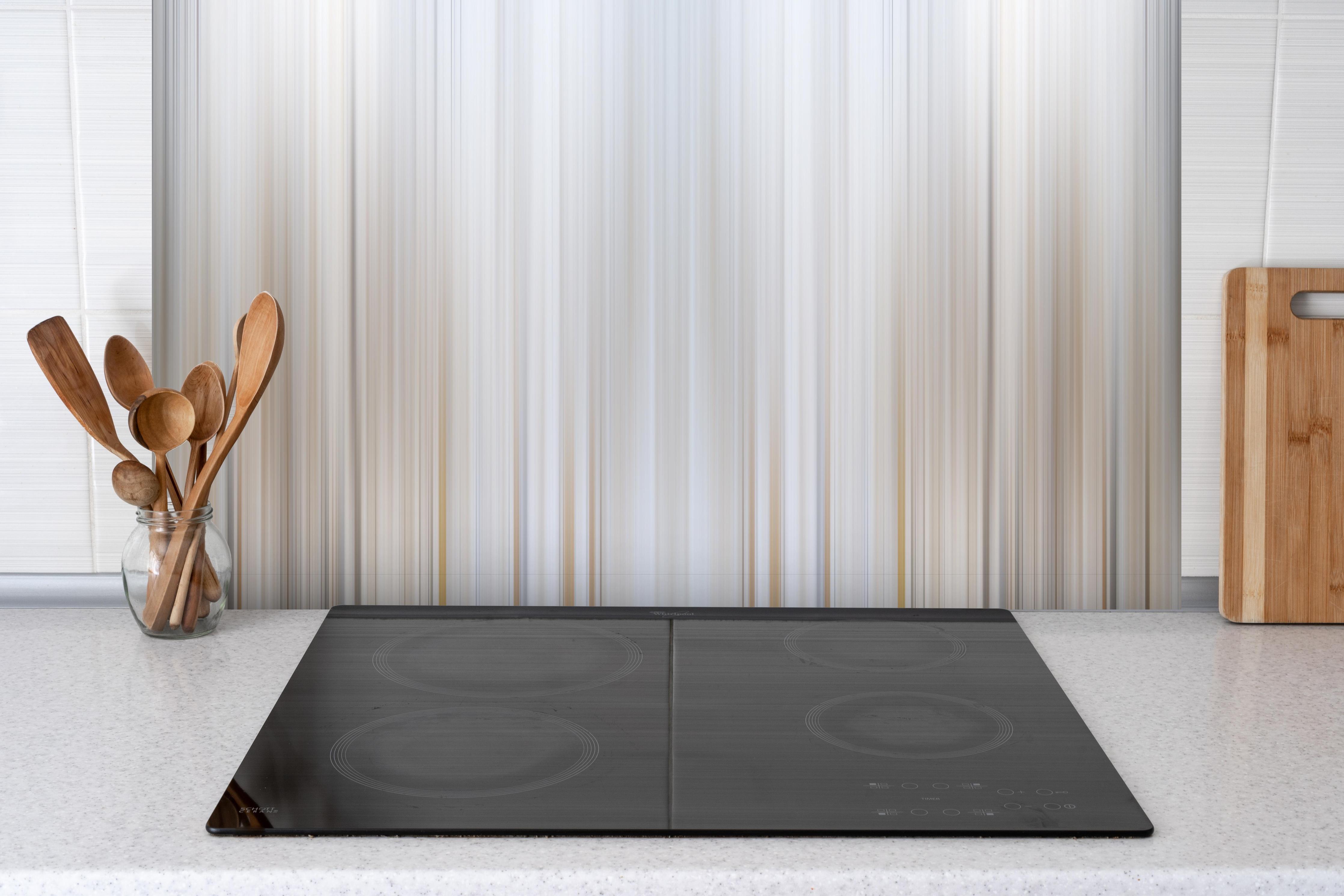 Spritzschutz - Abstrakte Vertikale Linien hinter einem Cerankochfeld zwischen Holz-Kochutensilien