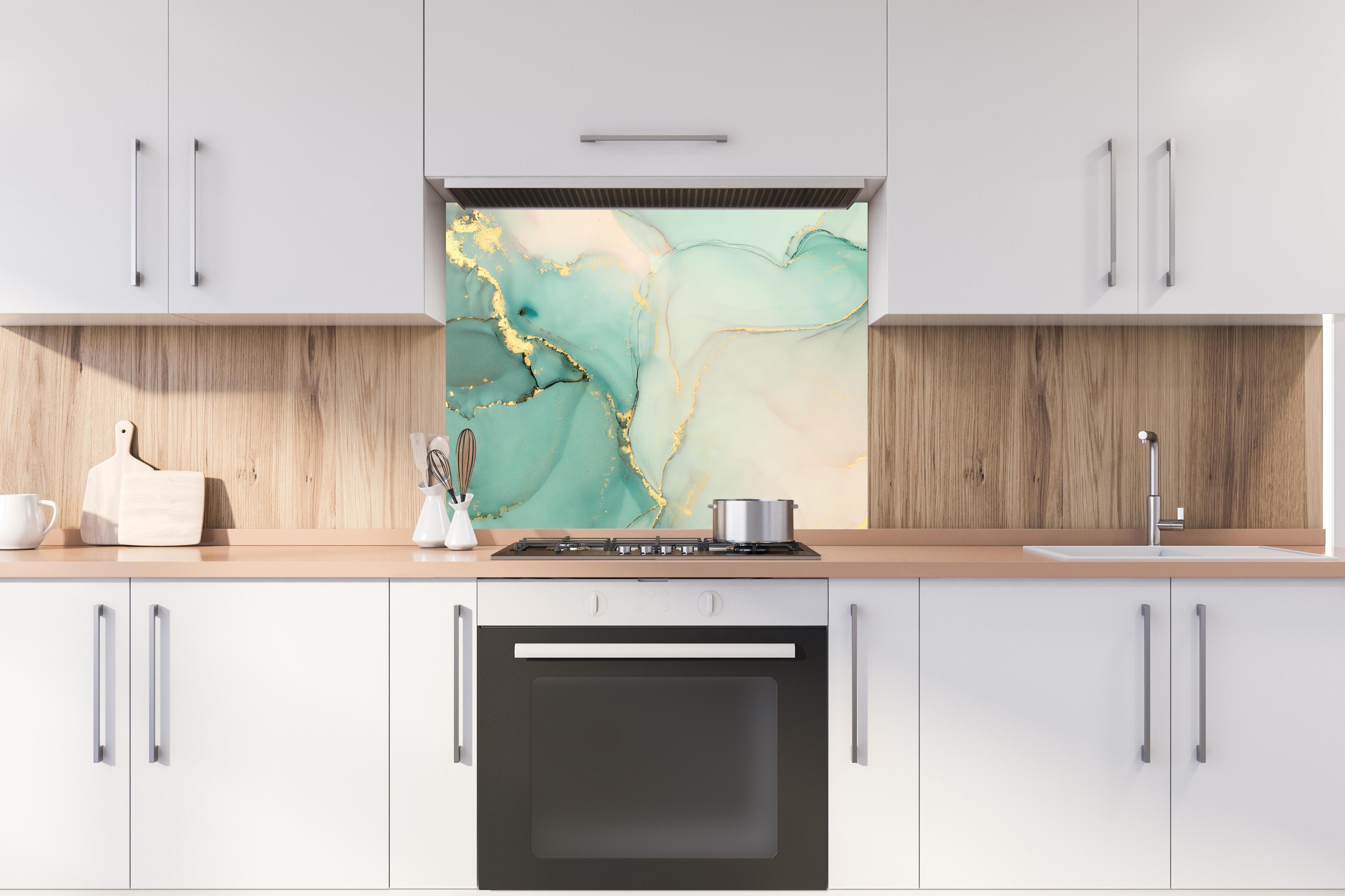 Spritzschutz - Abstrakte grünliche Muster mit goldenem Rand hinter stilvollem Gasherd unter Dunstabzugshaube