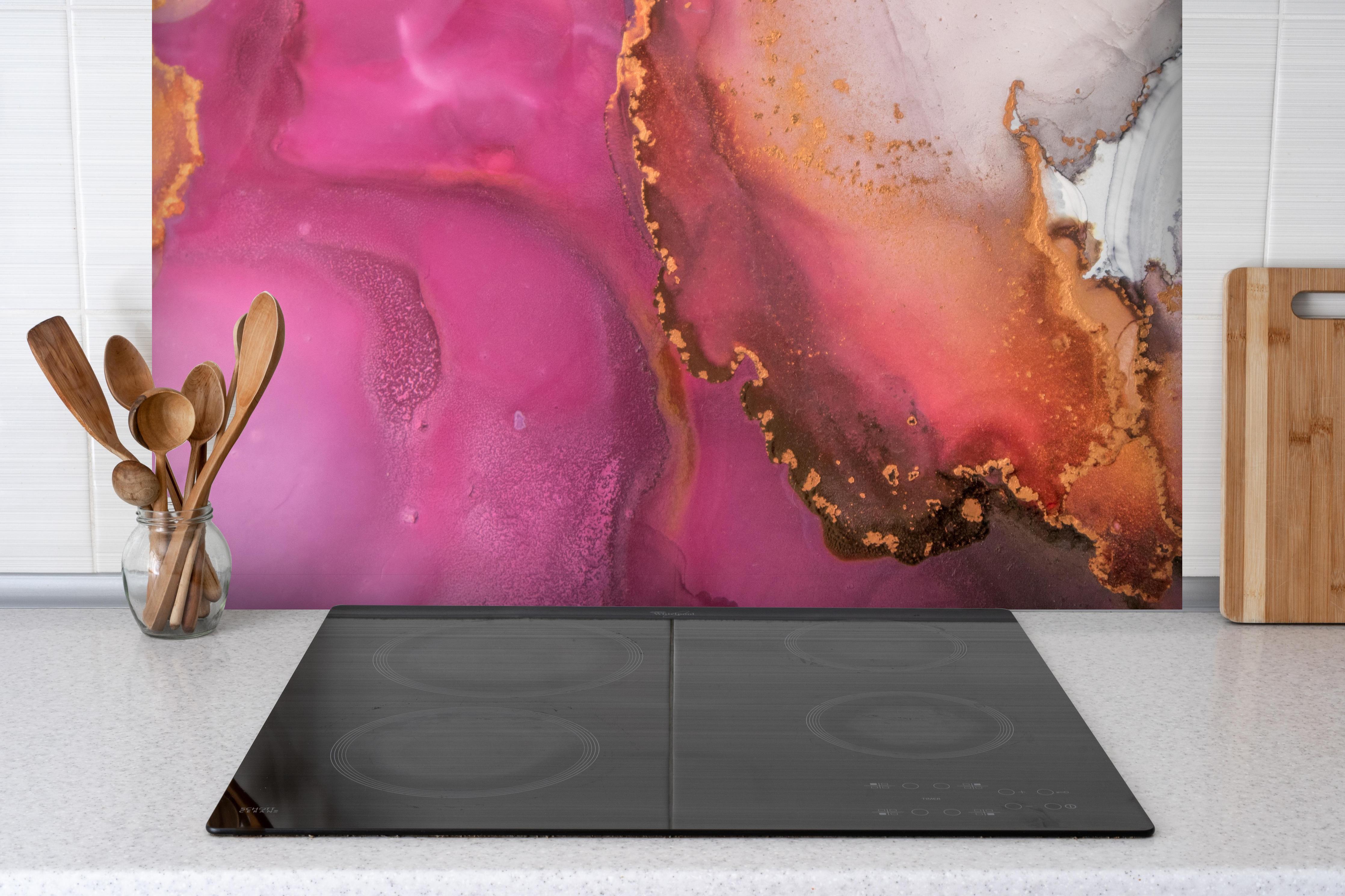 Spritzschutz - Abstrakte pinke Tinte mit Goldelementen hinter einem Cerankochfeld zwischen Holz-Kochutensilien