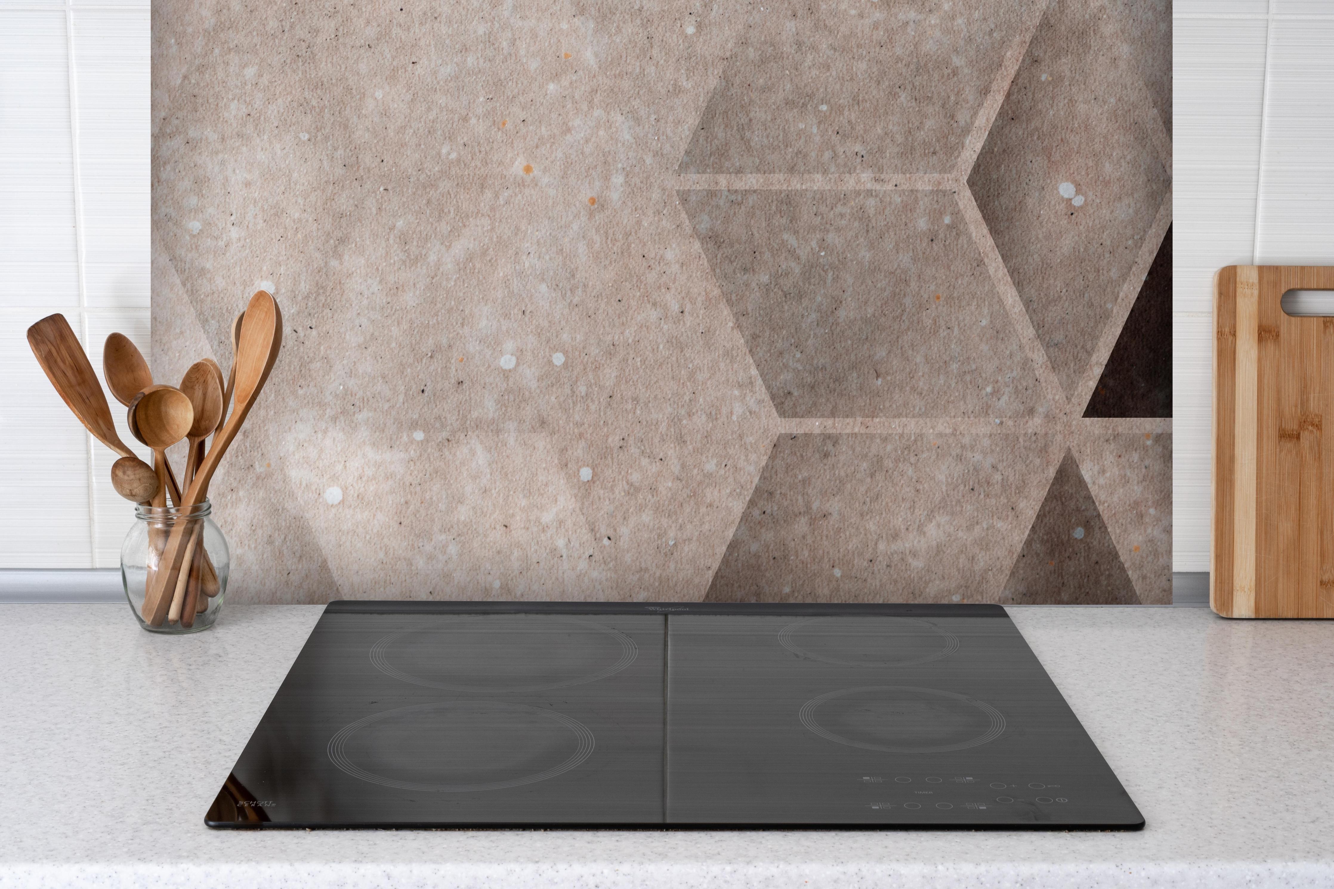 Spritzschutz - Abstrakter bräunliches kubisches Muster hinter einem Cerankochfeld zwischen Holz-Kochutensilien