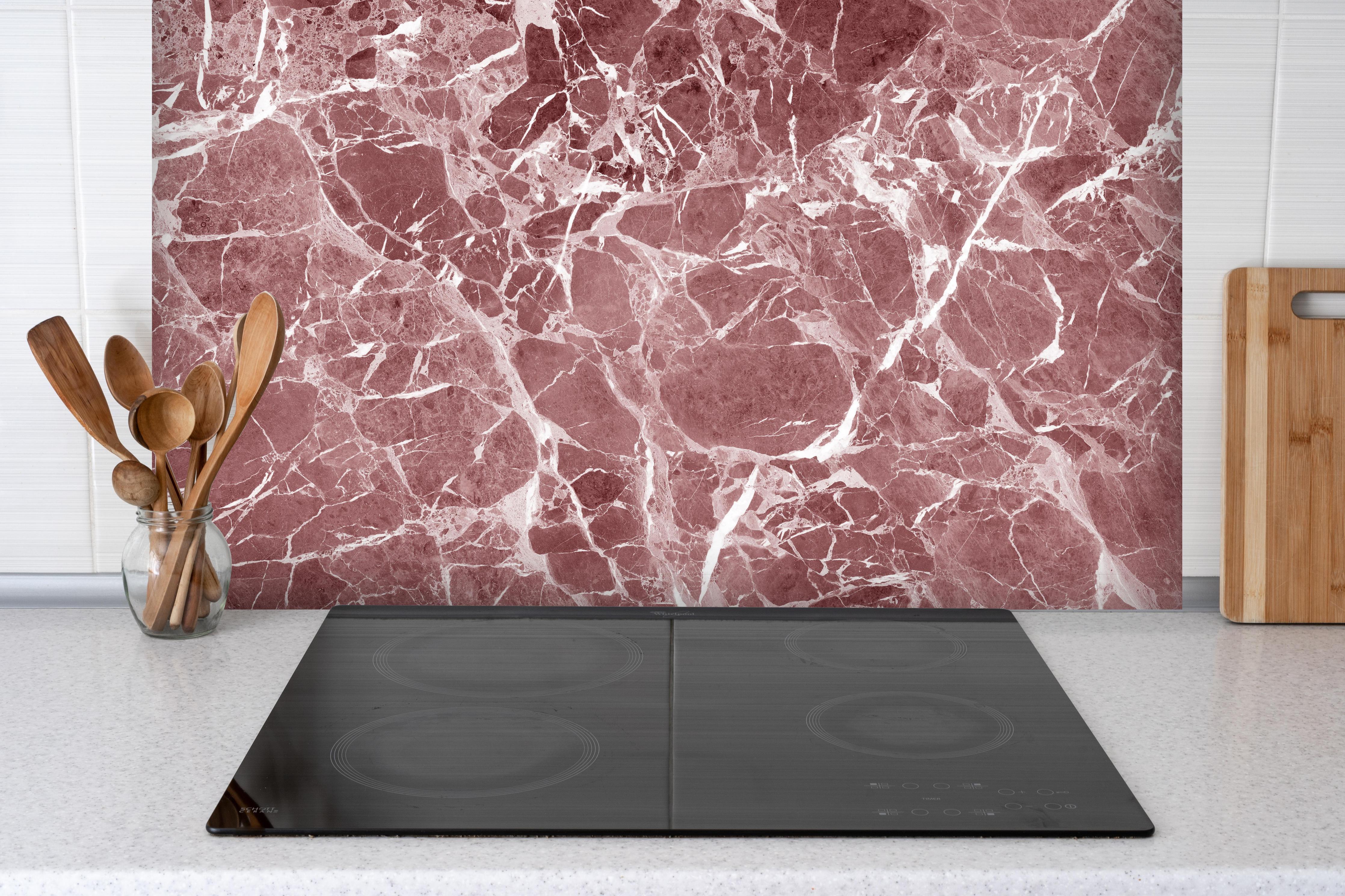 Spritzschutz - Abstrakter roter Marmor Textur hinter einem Cerankochfeld zwischen Holz-Kochutensilien