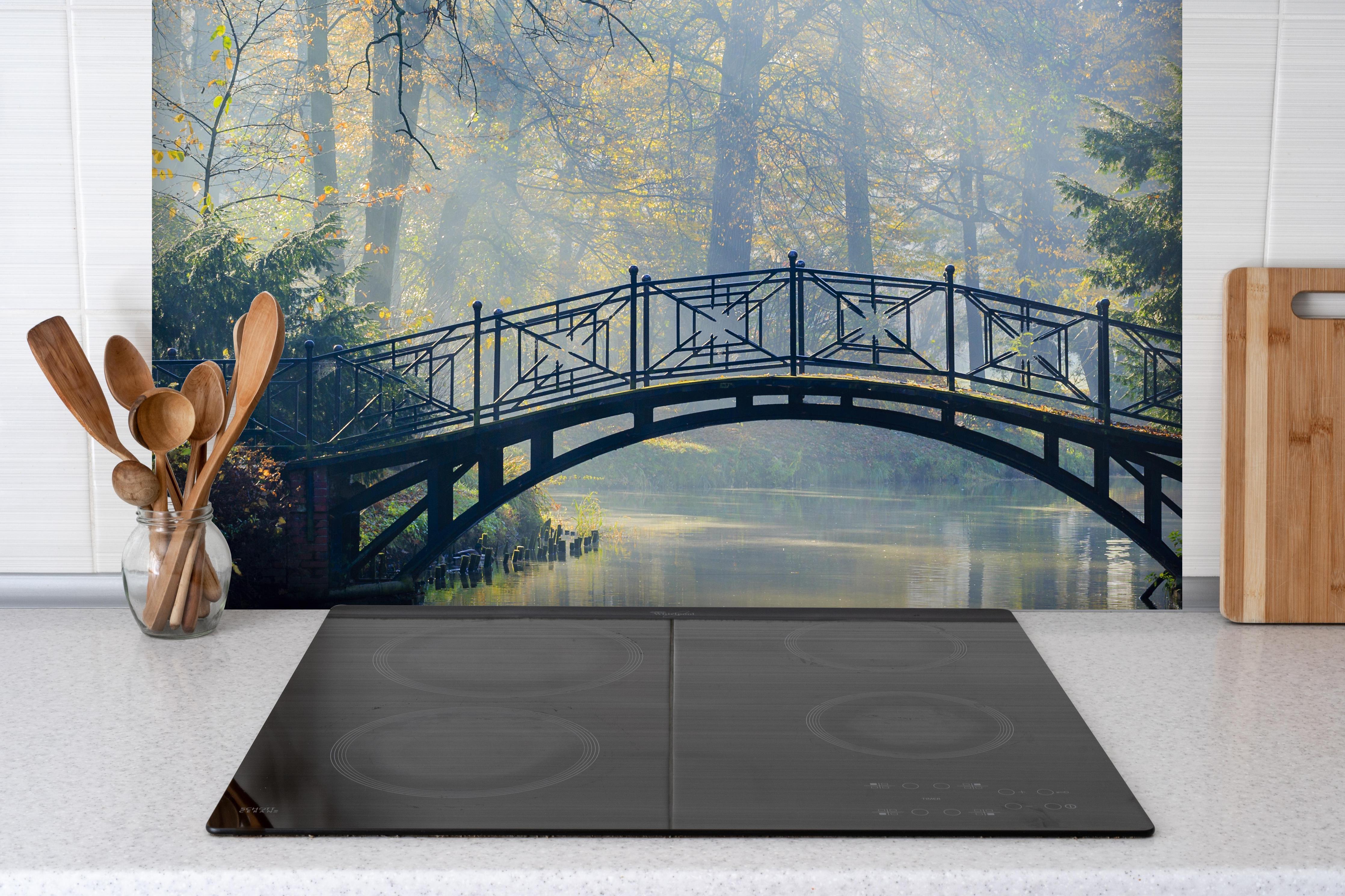 Spritzschutz - Alte Brücke im herbstlich nebligen Park hinter einem Cerankochfeld zwischen Holz-Kochutensilien