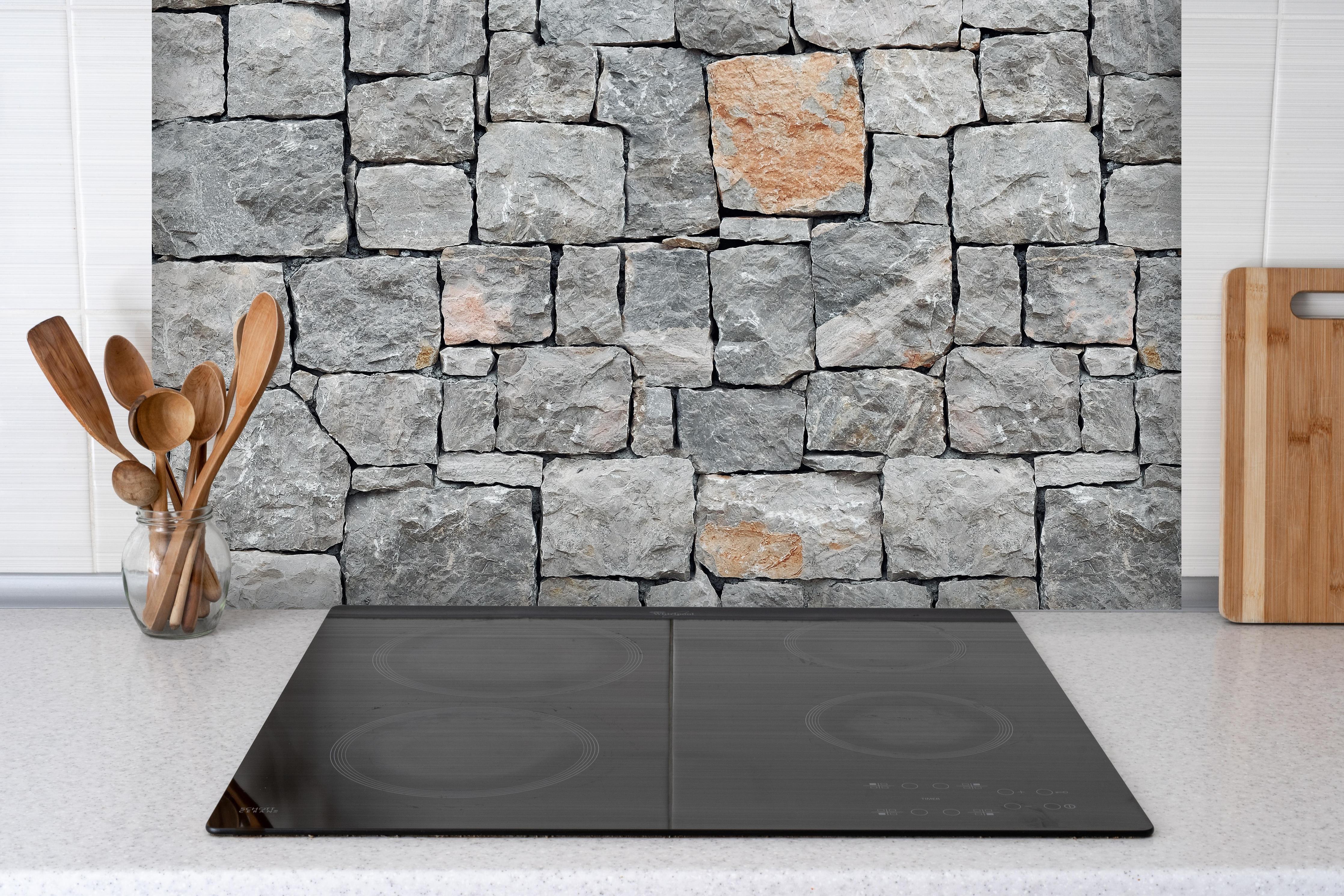 Spritzschutz - Alte Graue Steinwand hinter einem Cerankochfeld zwischen Holz-Kochutensilien