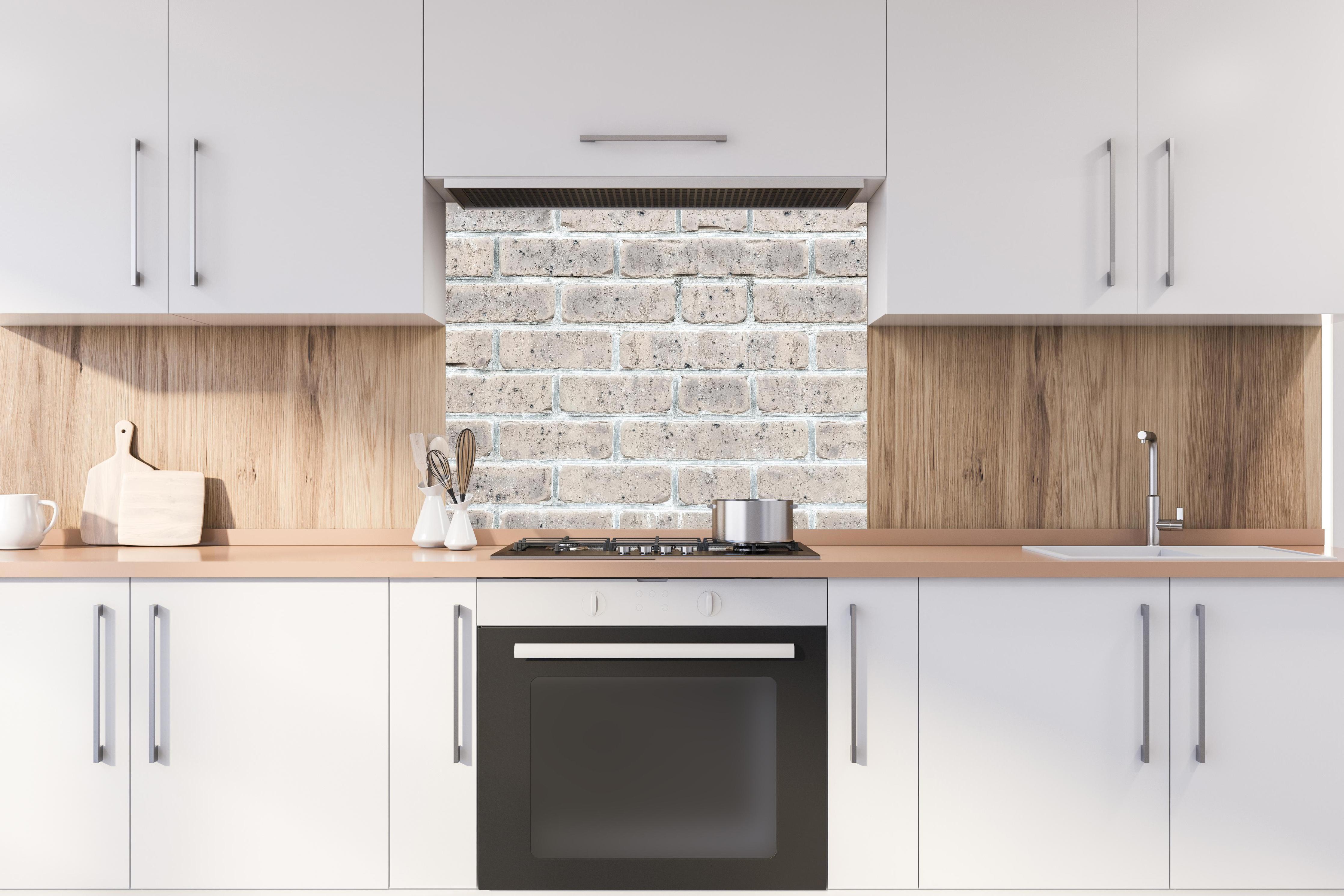 Spritzschutz - Alte weiße Vintage Backsteinmauer hinter stilvollem Gasherd unter Dunstabzugshaube