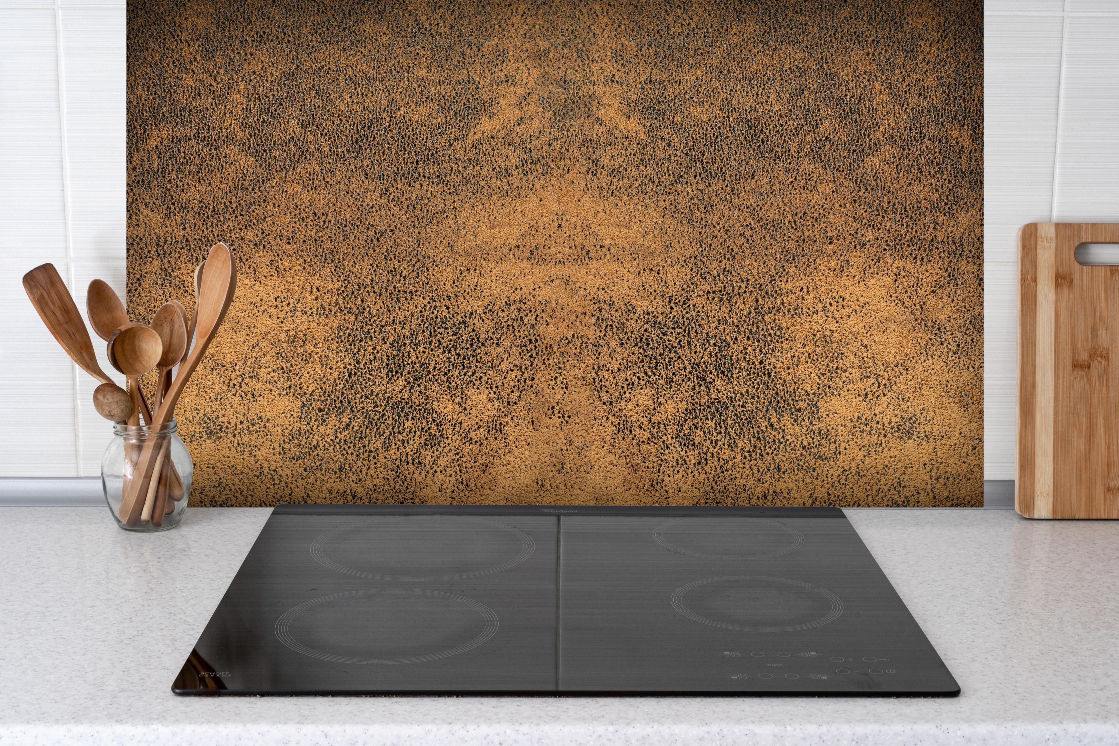 Spritzschutz - Altes braunes rustikales Leder hinter einem Cerankochfeld zwischen Holz-Kochutensilien