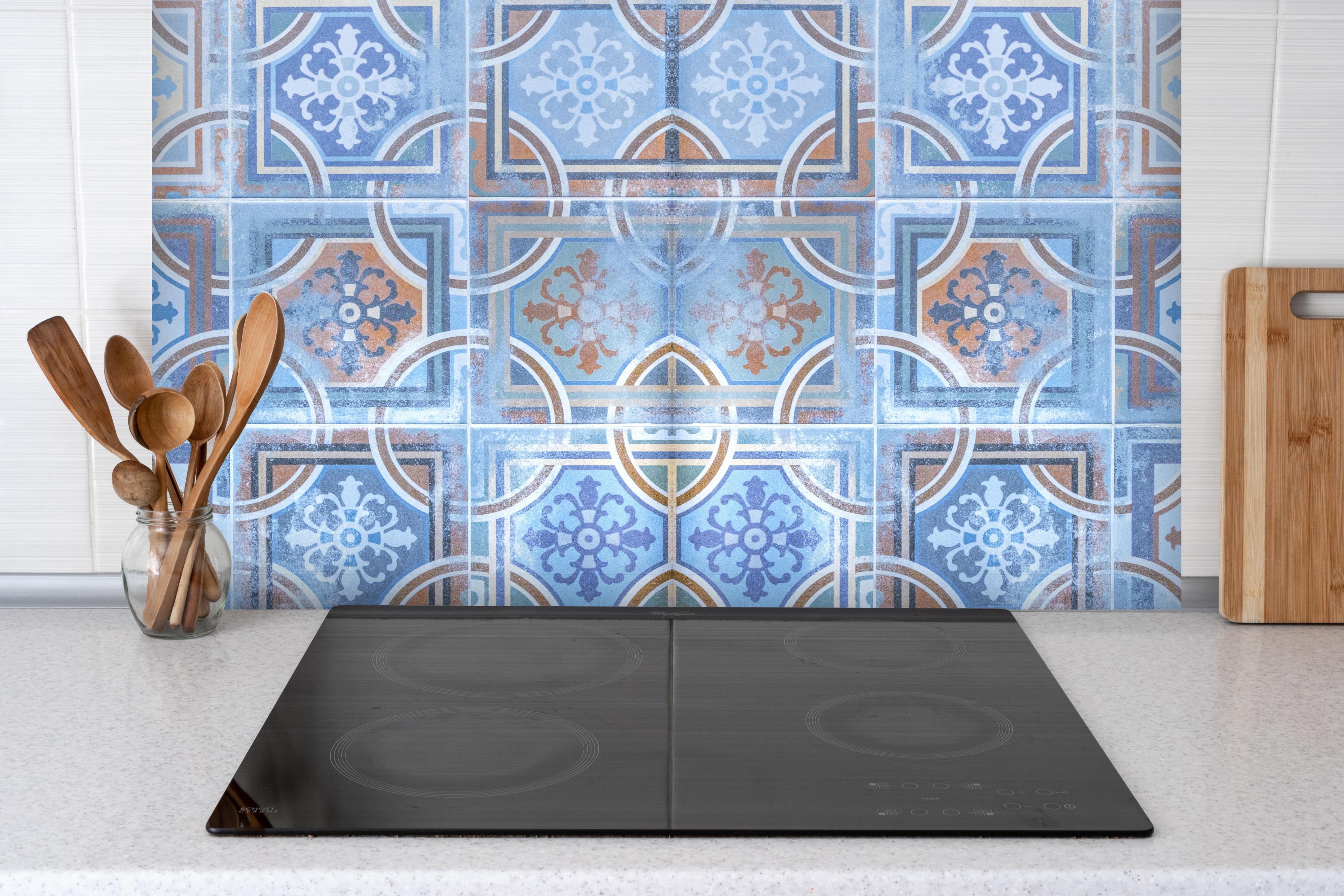 Spritzschutz - Arabische Fliesen Textur hinter einem Cerankochfeld zwischen Holz-Kochutensilien