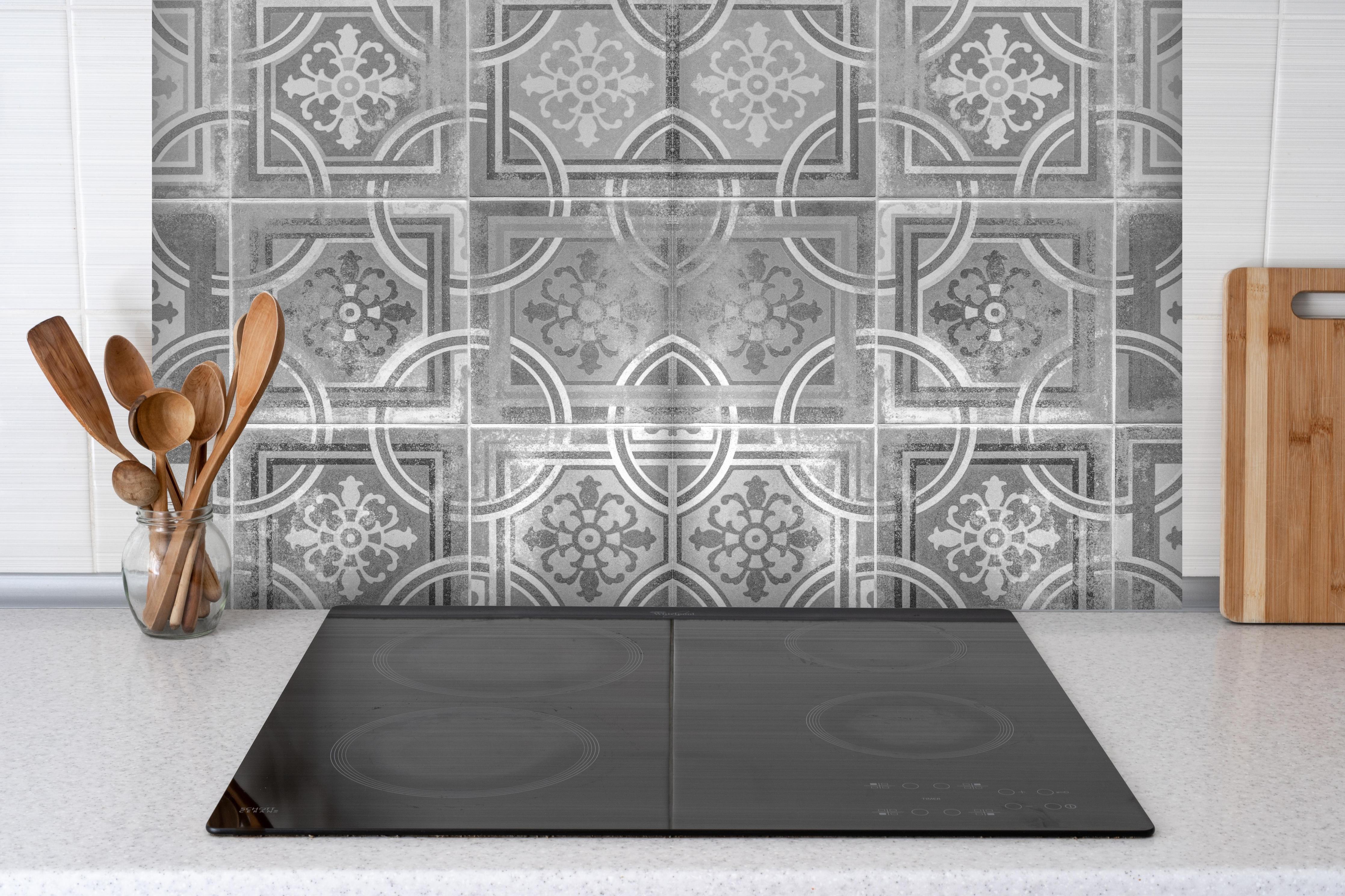 Spritzschutz - Arabische schäbige Fliesen Hintergrund hinter einem Cerankochfeld zwischen Holz-Kochutensilien