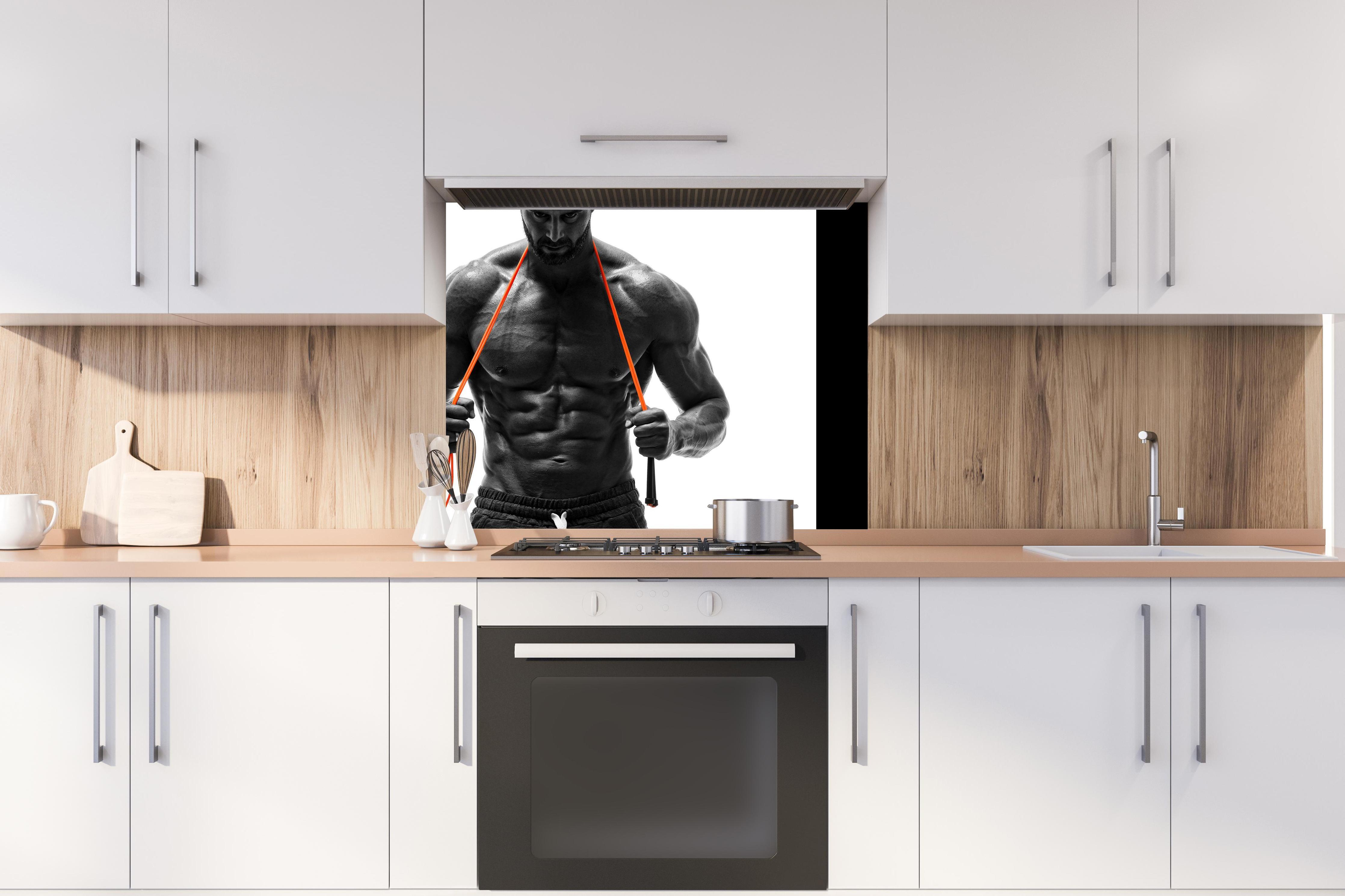 Spritzschutz - Athletischer Mann posiert mit Sprungseil hinter stilvollem Gasherd unter Dunstabzugshaube
