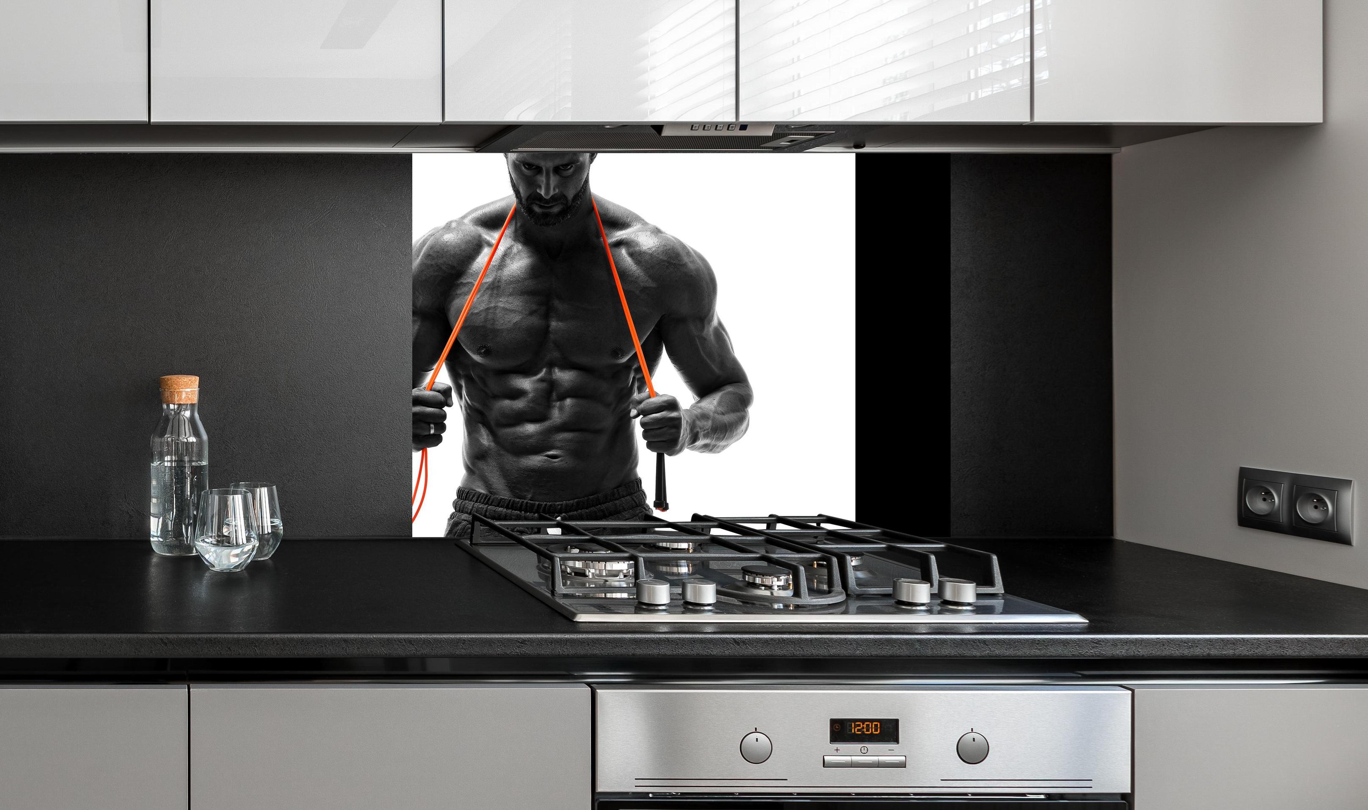 Spritzschutz - Athletischer Mann posiert mit Sprungseil an edler Anthrazit-Wand hinter silbernem Gasherd