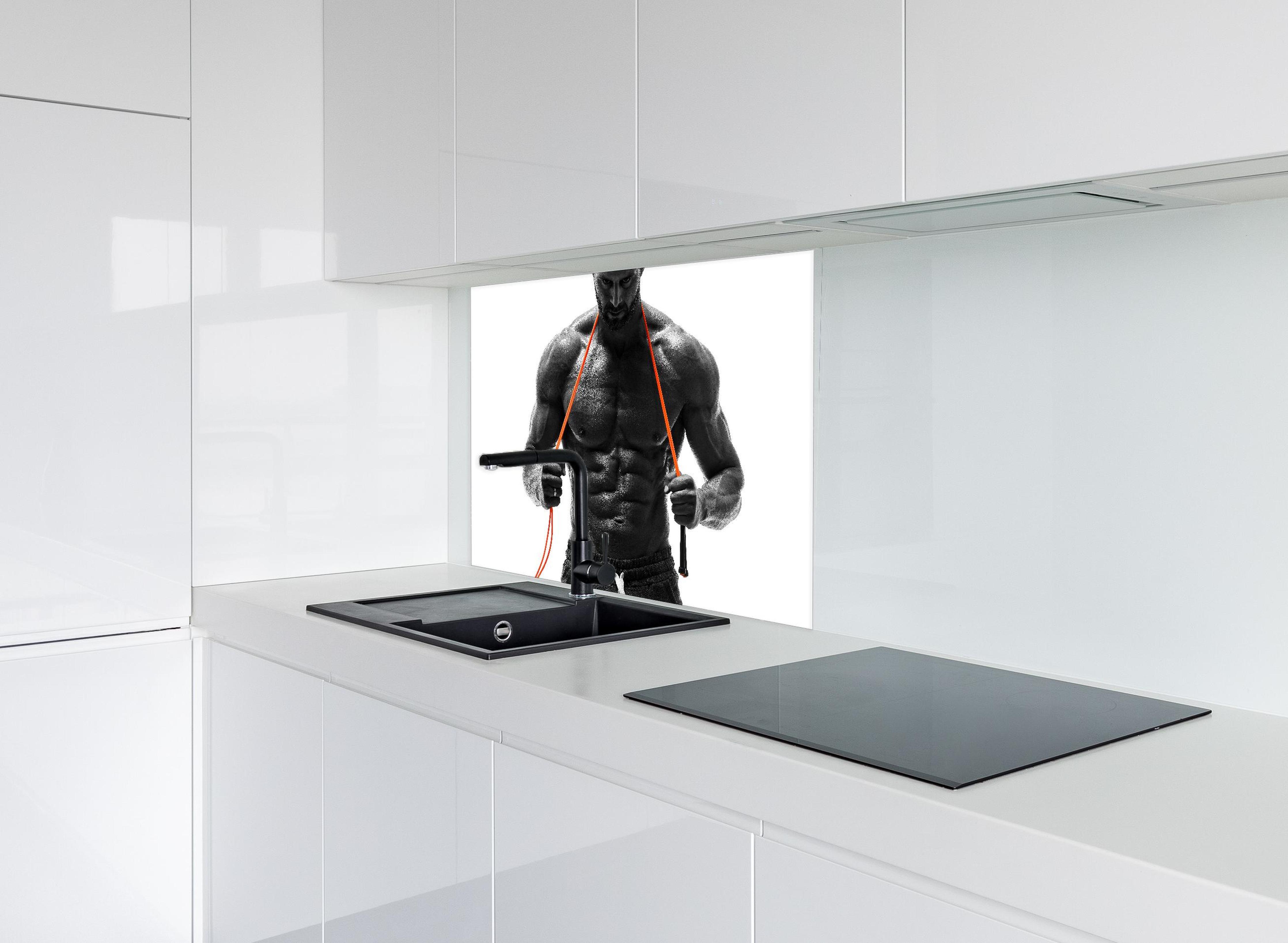 Spritzschutz - Athletischer Mann posiert mit Sprungseil hinter modernem schwarz-matten Spülbecken in weißer Hochglanz-Küche
