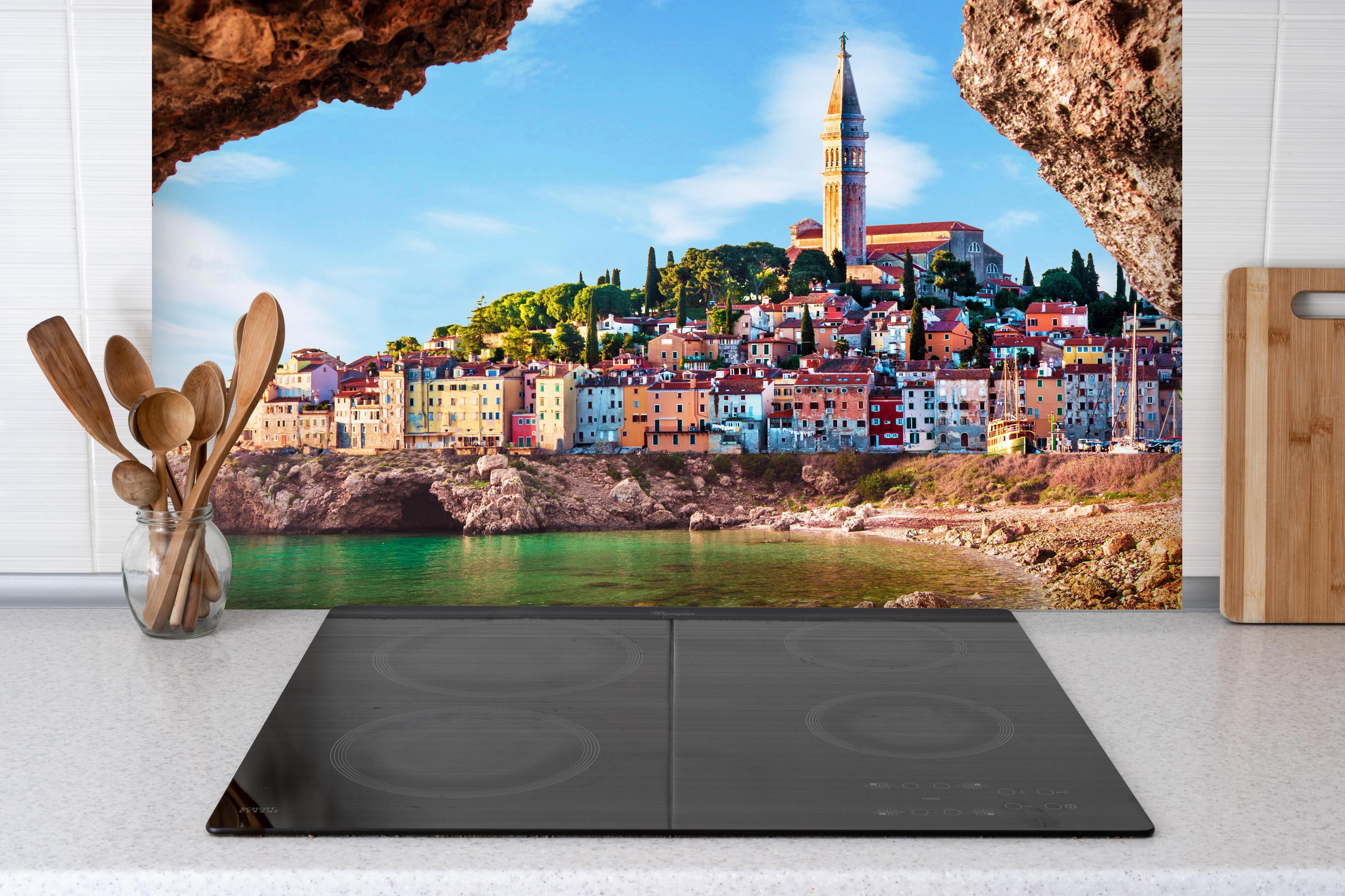 Spritzschutz - Außergewöhnlicher Blick auf alte Uhr in Piran hinter einem Cerankochfeld zwischen Holz-Kochutensilien