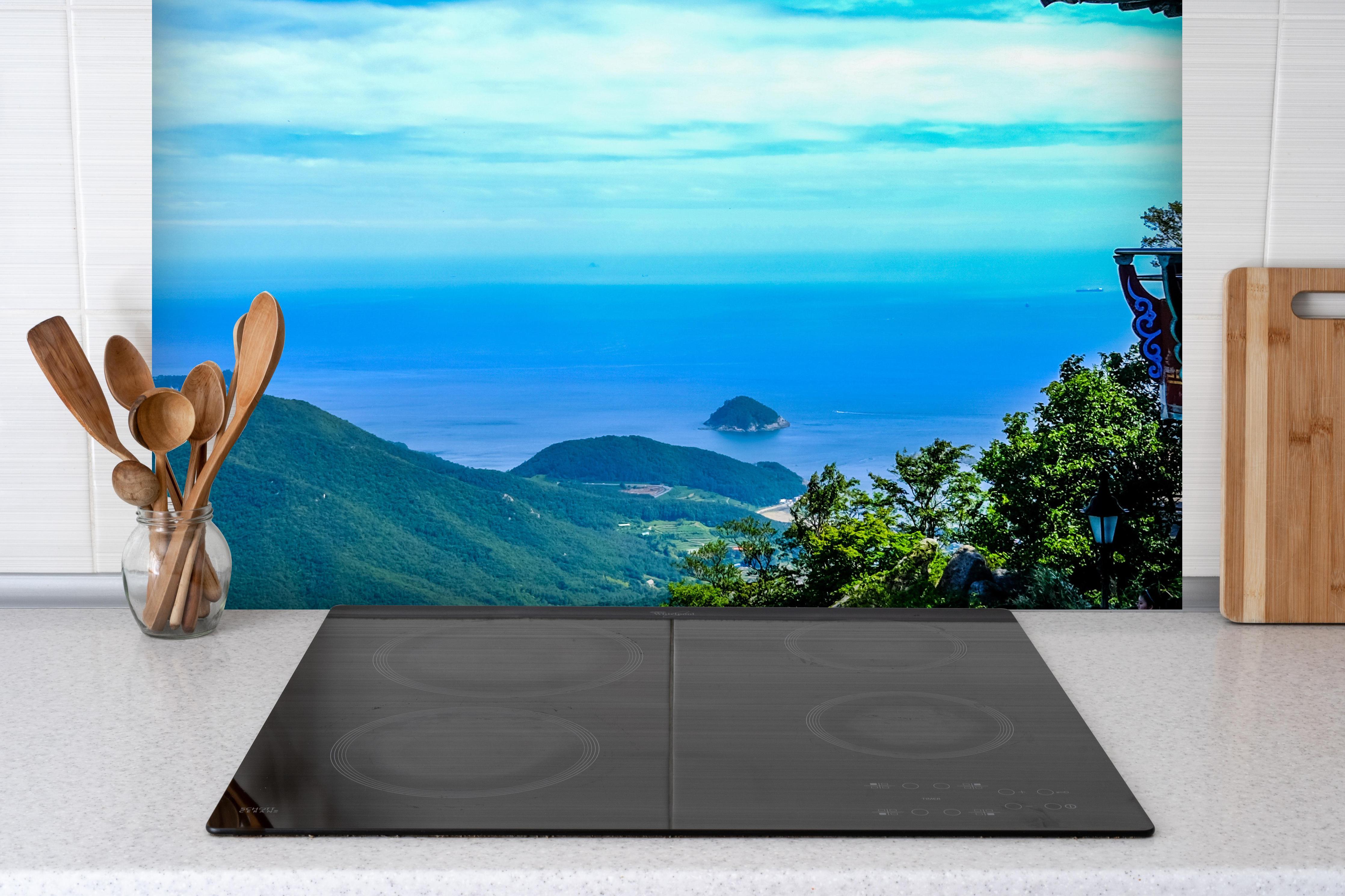 Spritzschutz - Aussicht eines Berges in Südkorea hinter einem Cerankochfeld zwischen Holz-Kochutensilien