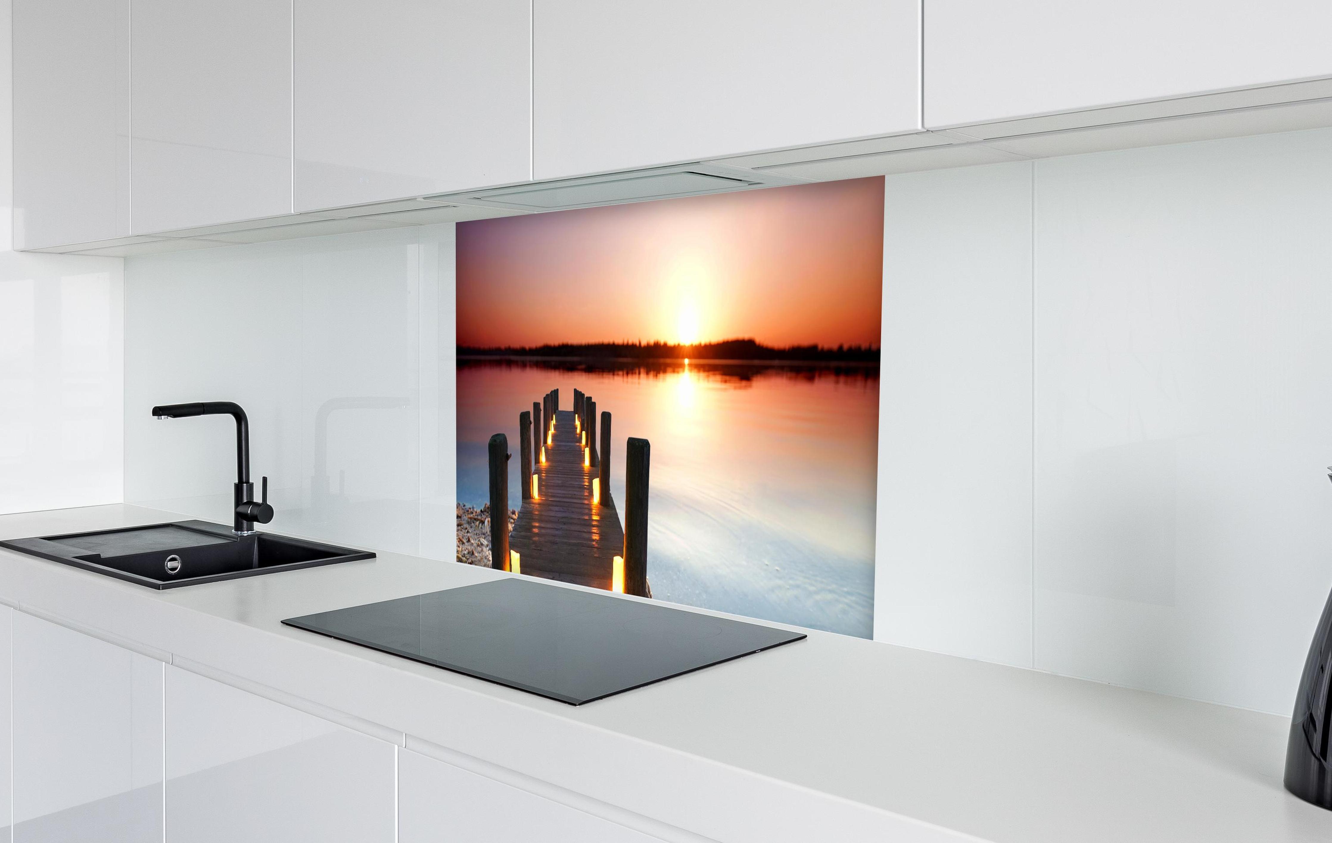 Spritzschutz - Beleuchteter romantischer Steg am Strand in weißer Hochglanz-Küche hinter einem Cerankochfeld