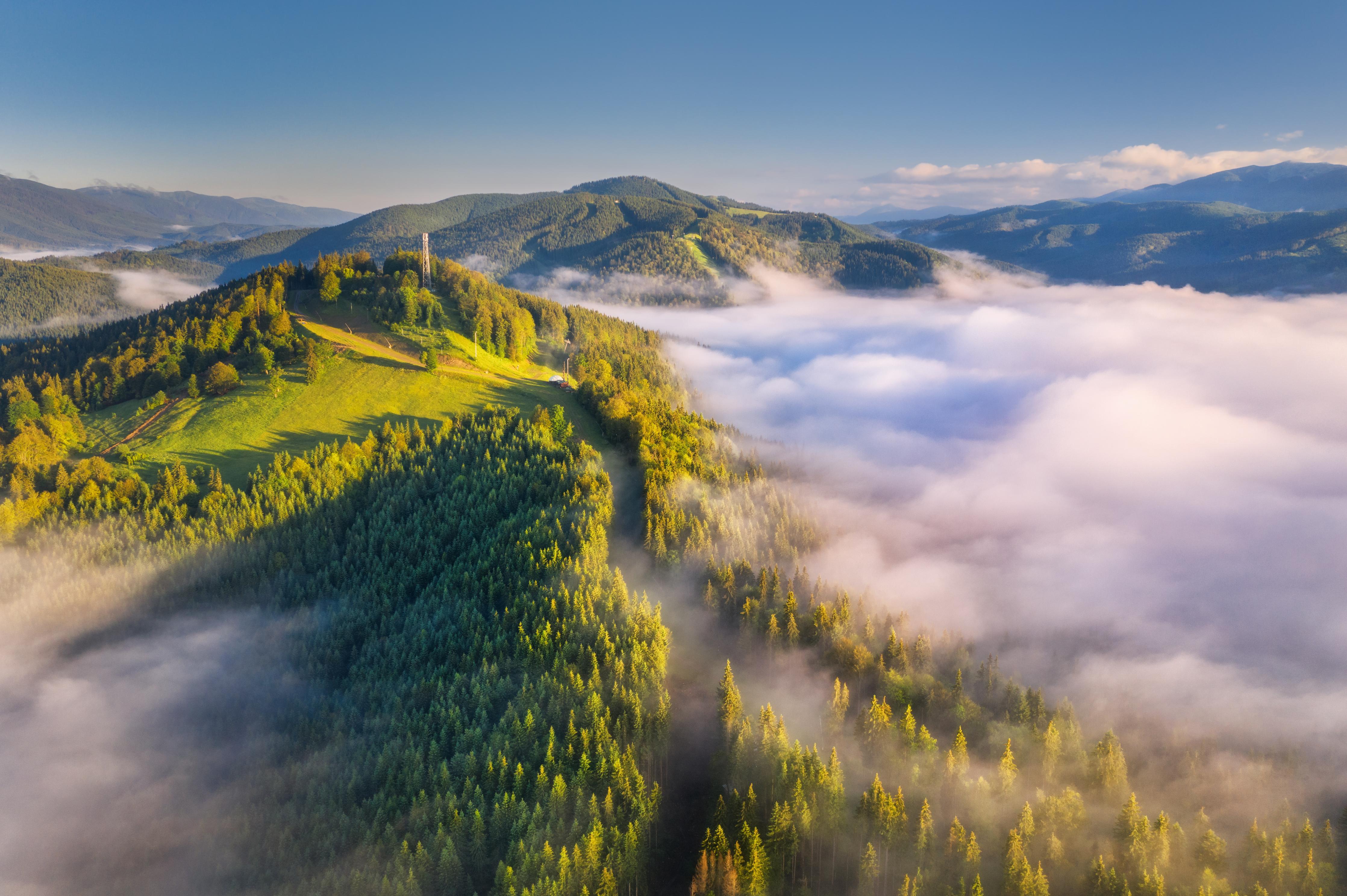 Spritzschutz-Berge in Wolken bei Sonnenaufgang im Sommer