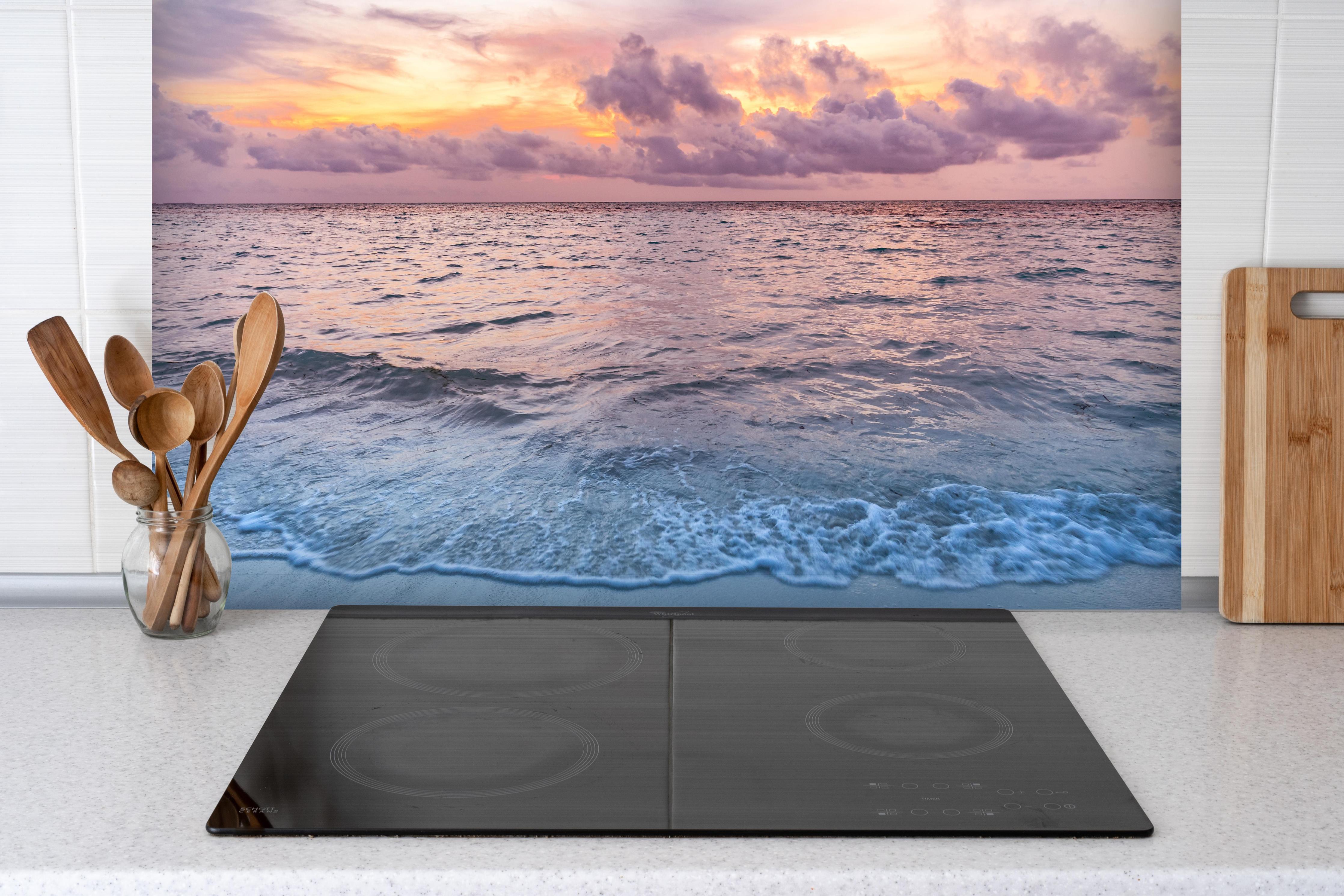 Spritzschutz - Bewölkter Sonnenuntergang am Strand hinter einem Cerankochfeld zwischen Holz-Kochutensilien