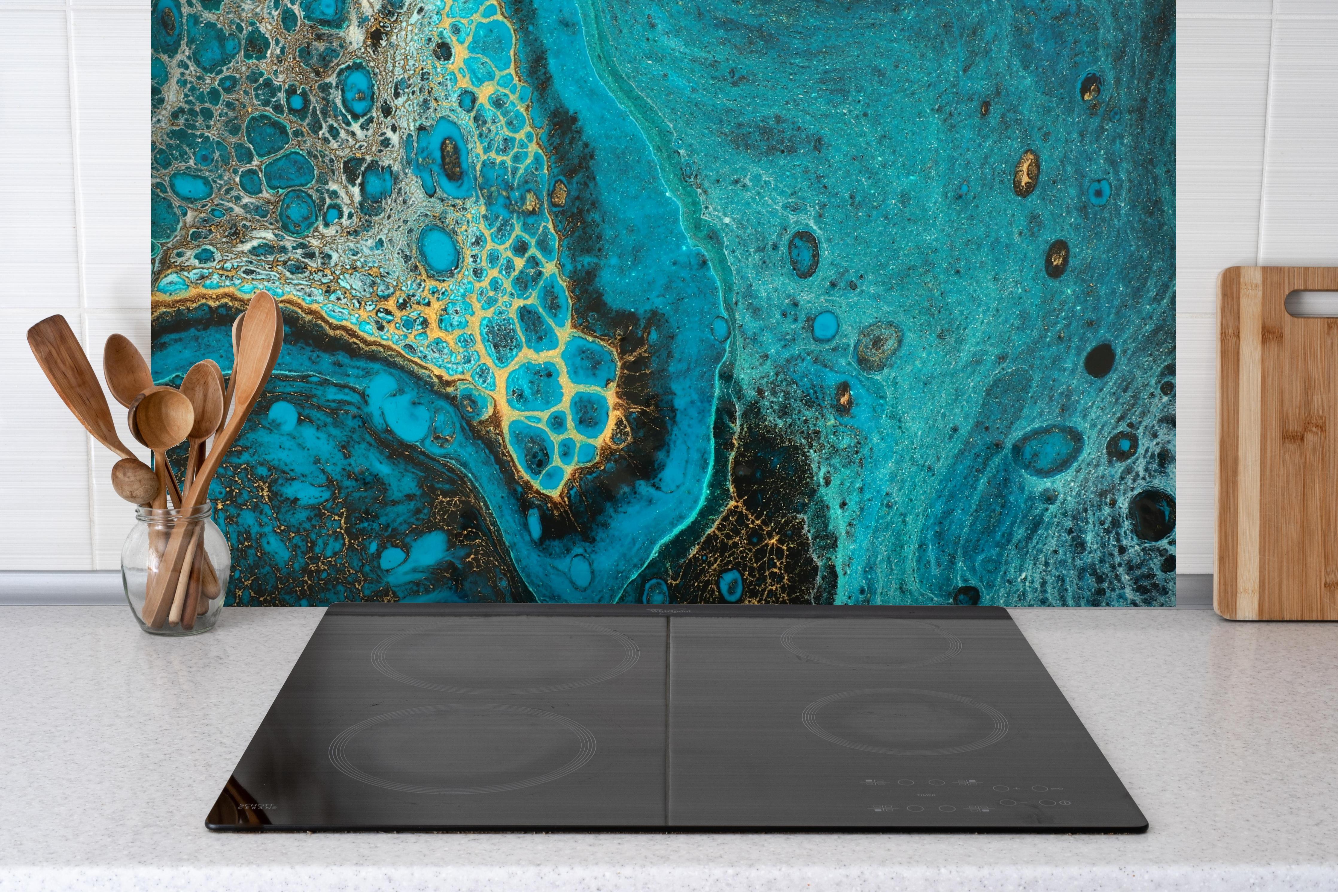 Spritzschutz - Bläulicher Marmor hinter einem Cerankochfeld zwischen Holz-Kochutensilien