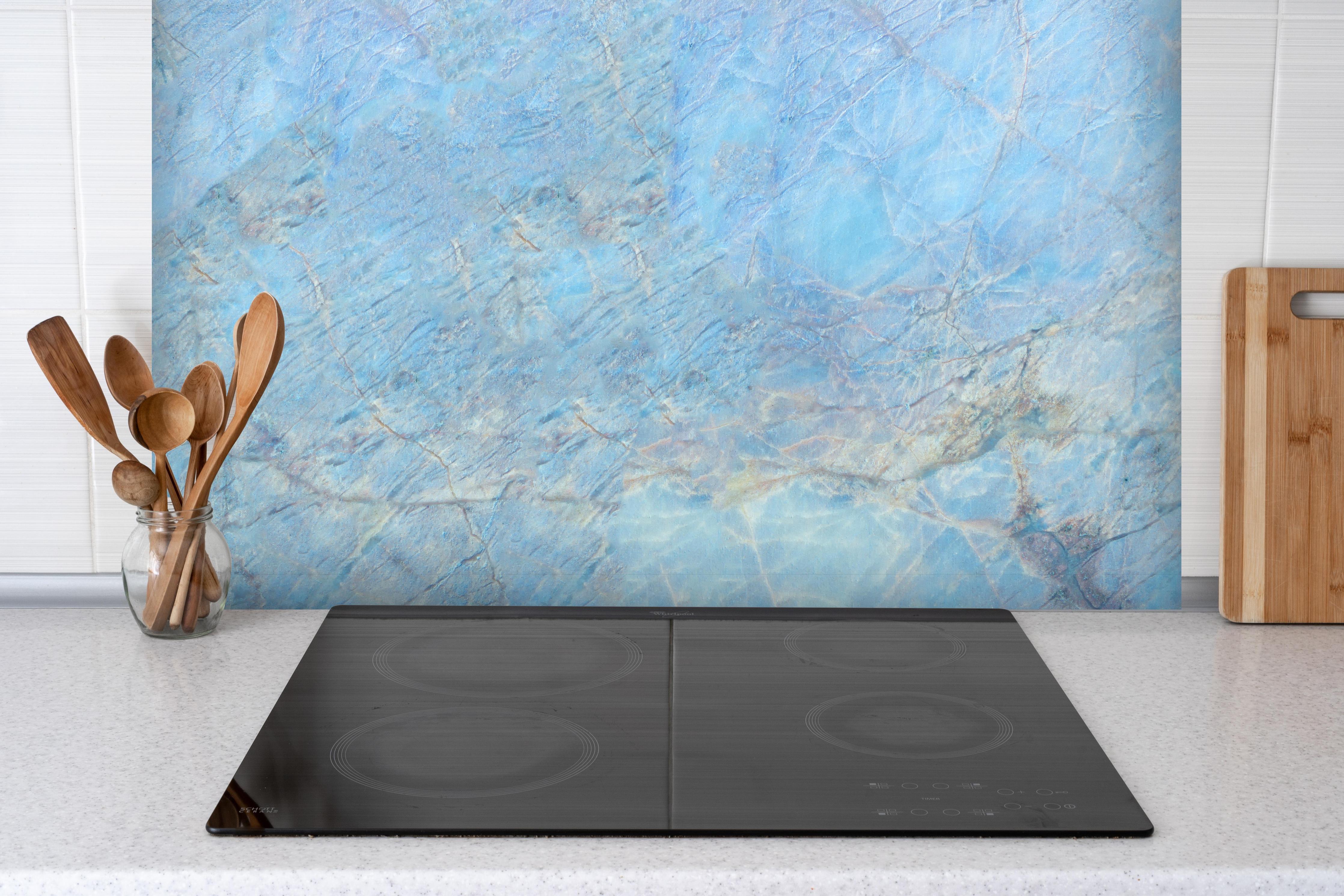 Spritzschutz - Bläulicher Marmor hinter einem Cerankochfeld zwischen Holz-Kochutensilien