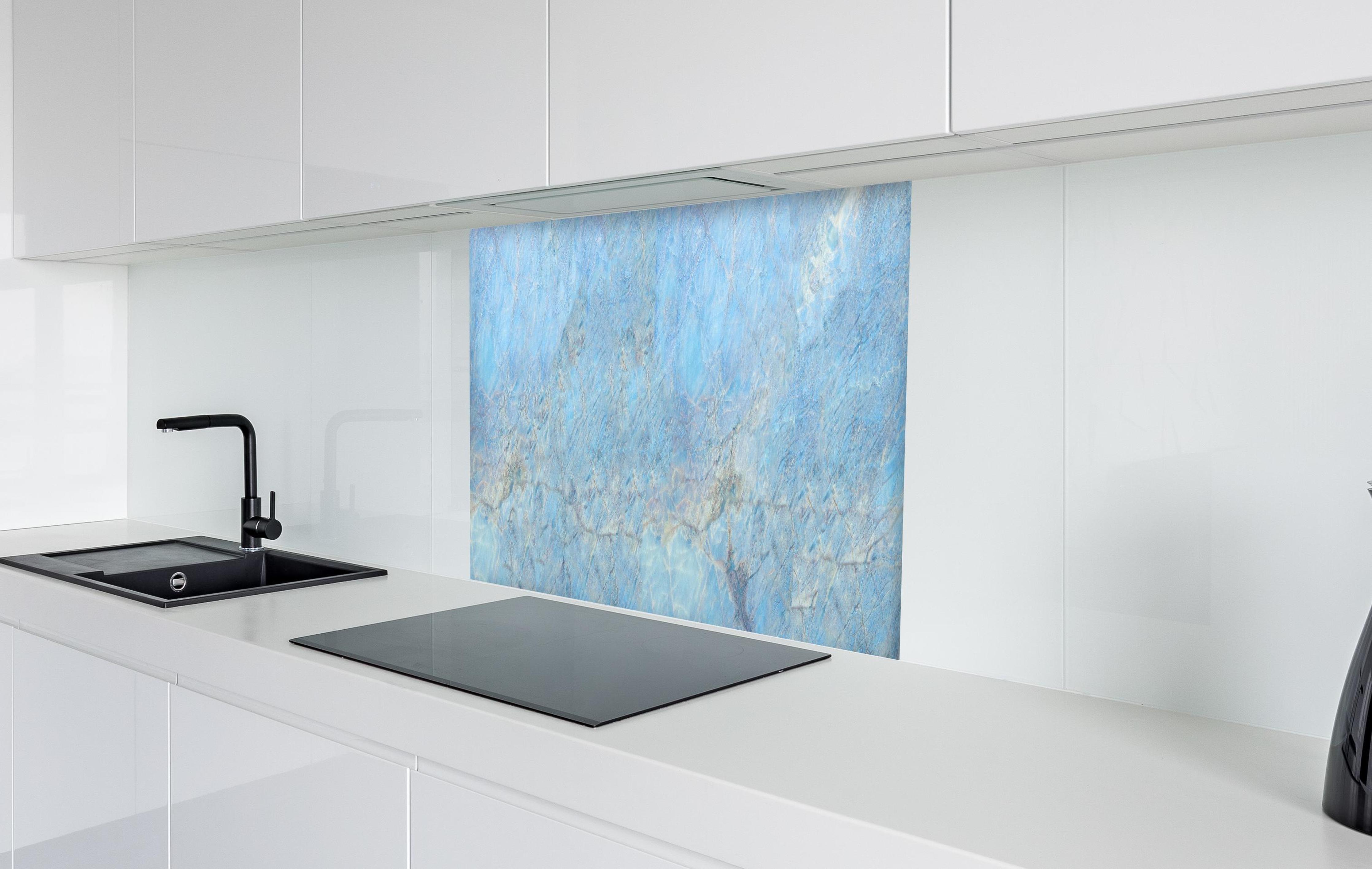 Spritzschutz - Bläulicher Marmor in weißer Hochglanz-Küche hinter einem Cerankochfeld
