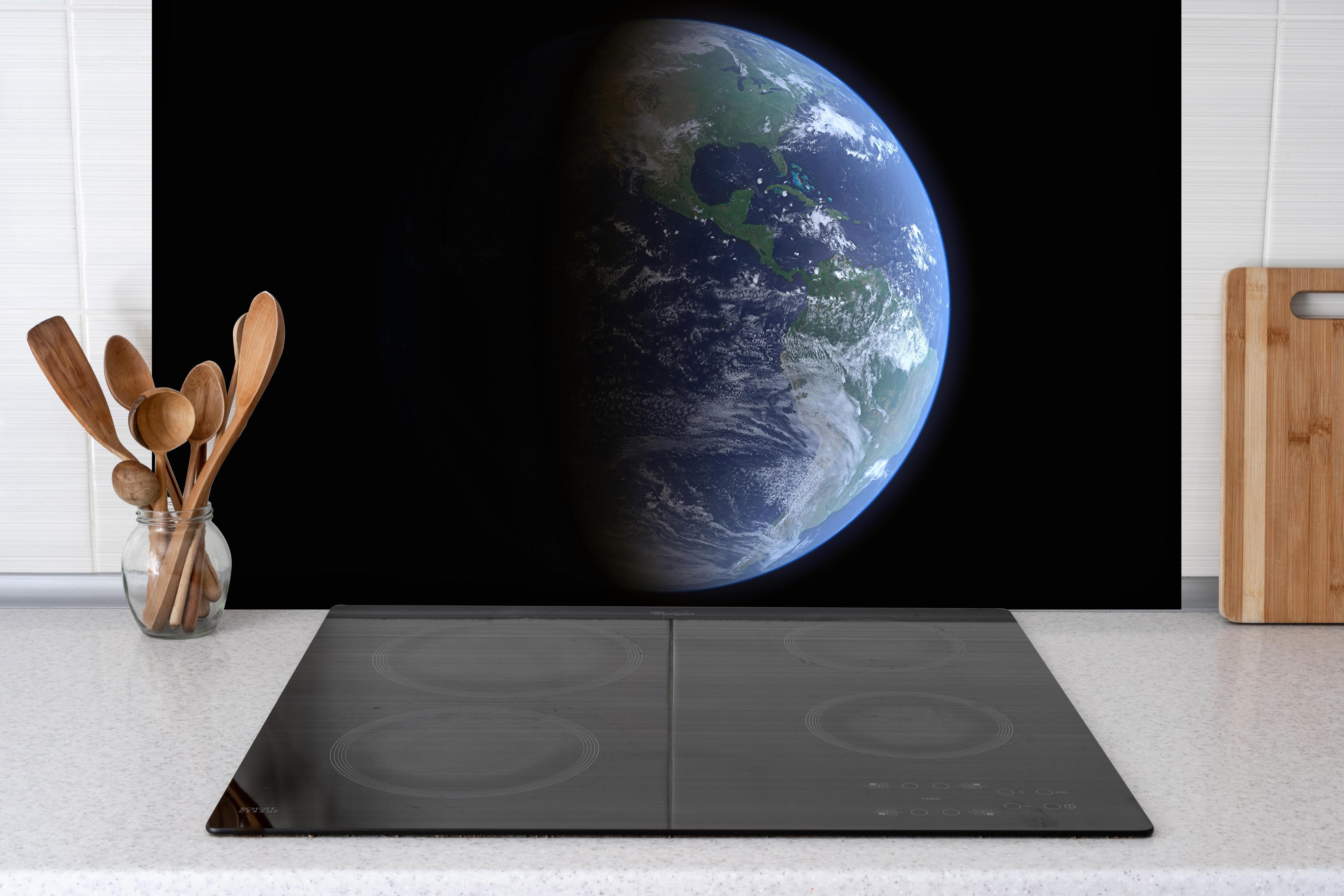 Spritzschutz - Blick auf die Erde vom Weltall hinter einem Cerankochfeld zwischen Holz-Kochutensilien